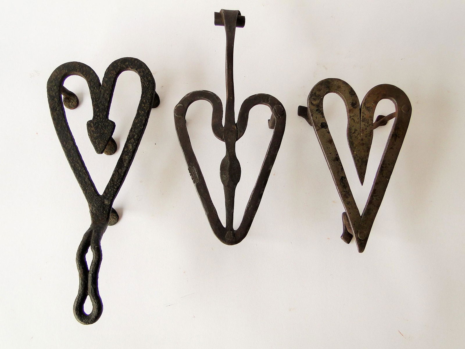 THREE 19TH C IRON HEART SHAPED TRIVETS: THREE 19TH C IRON HEART SHAPED TRIVETS, ONE WITH INITIALS MC
