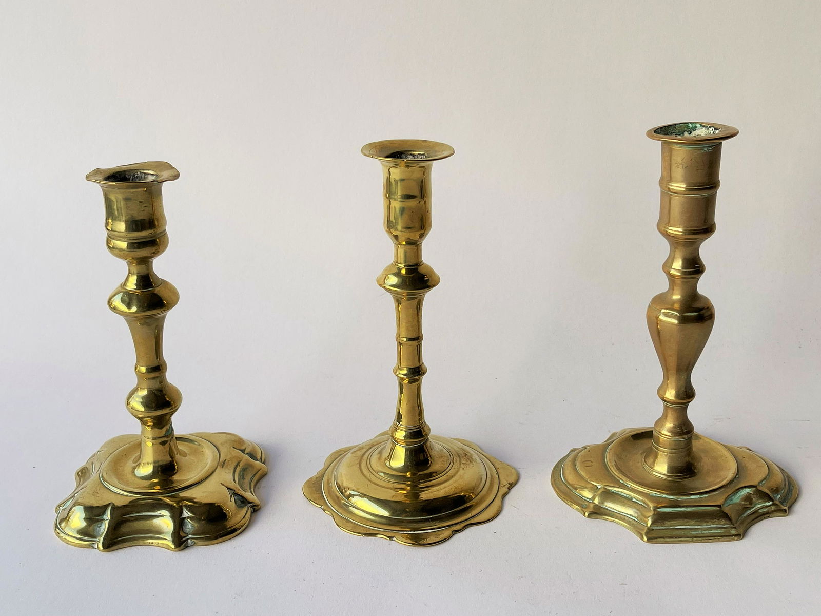 THREE ENGLISH BRASS QUEEN ANNE  PETAL BASE CANDLESTICKS (1 of 3)