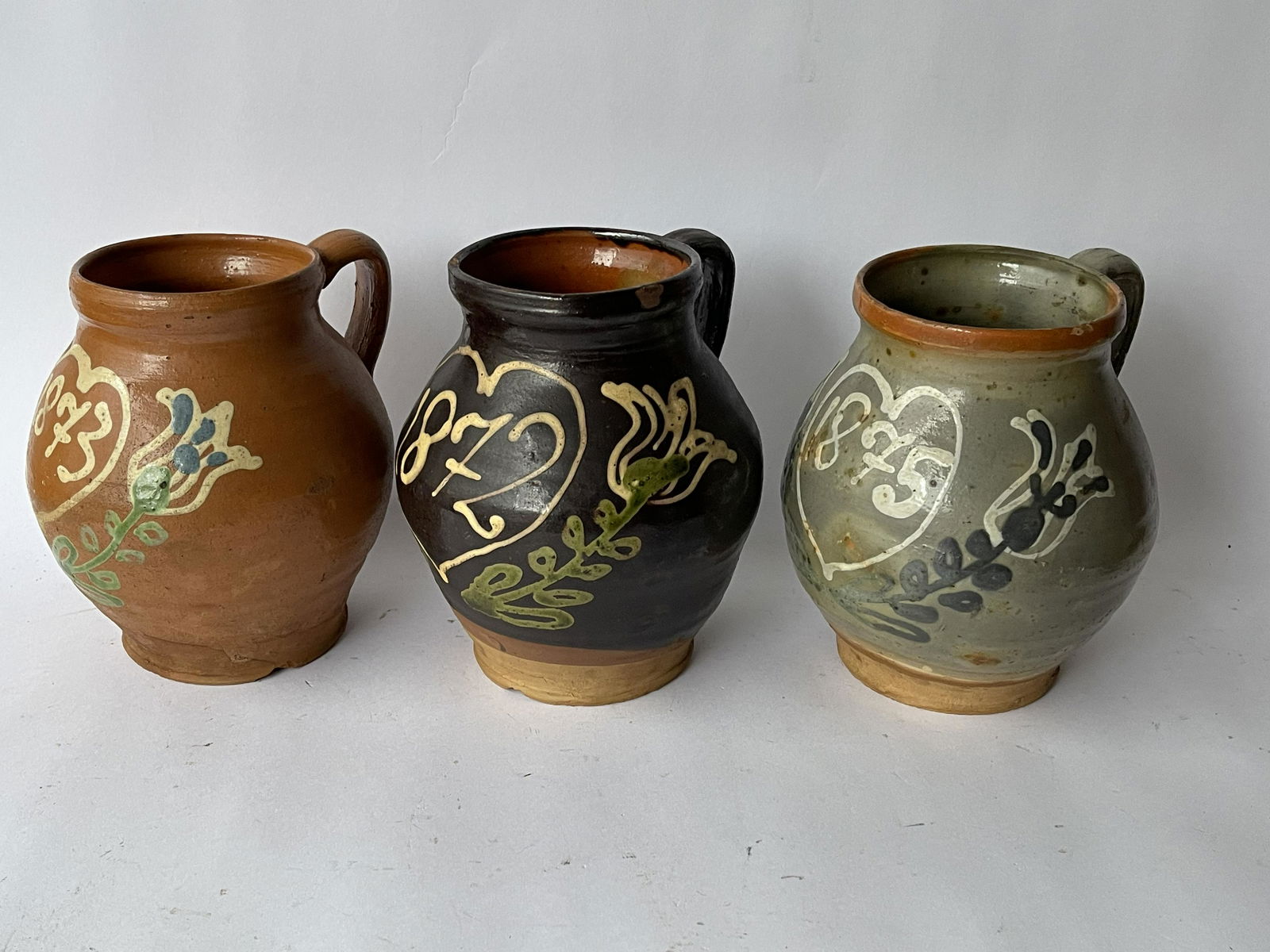 THREE DECORATED STONEWARE PITCHERS DATED (1 of 2)