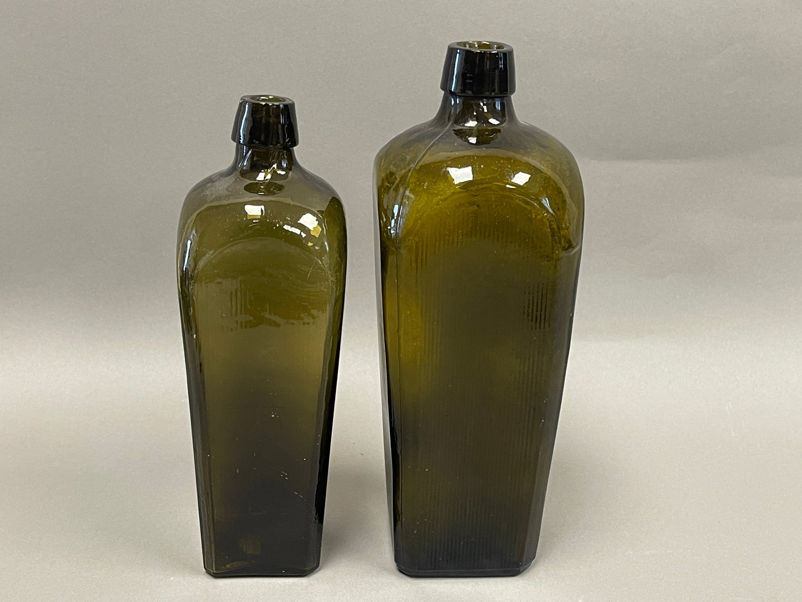 2- 18TH C OLIVE GREEN RIBBED WINE BOTTLES: 2- 18TH C OLIVE GREEN RIBBED WINE BOTTLES 9 ½” AND 10 ¾”