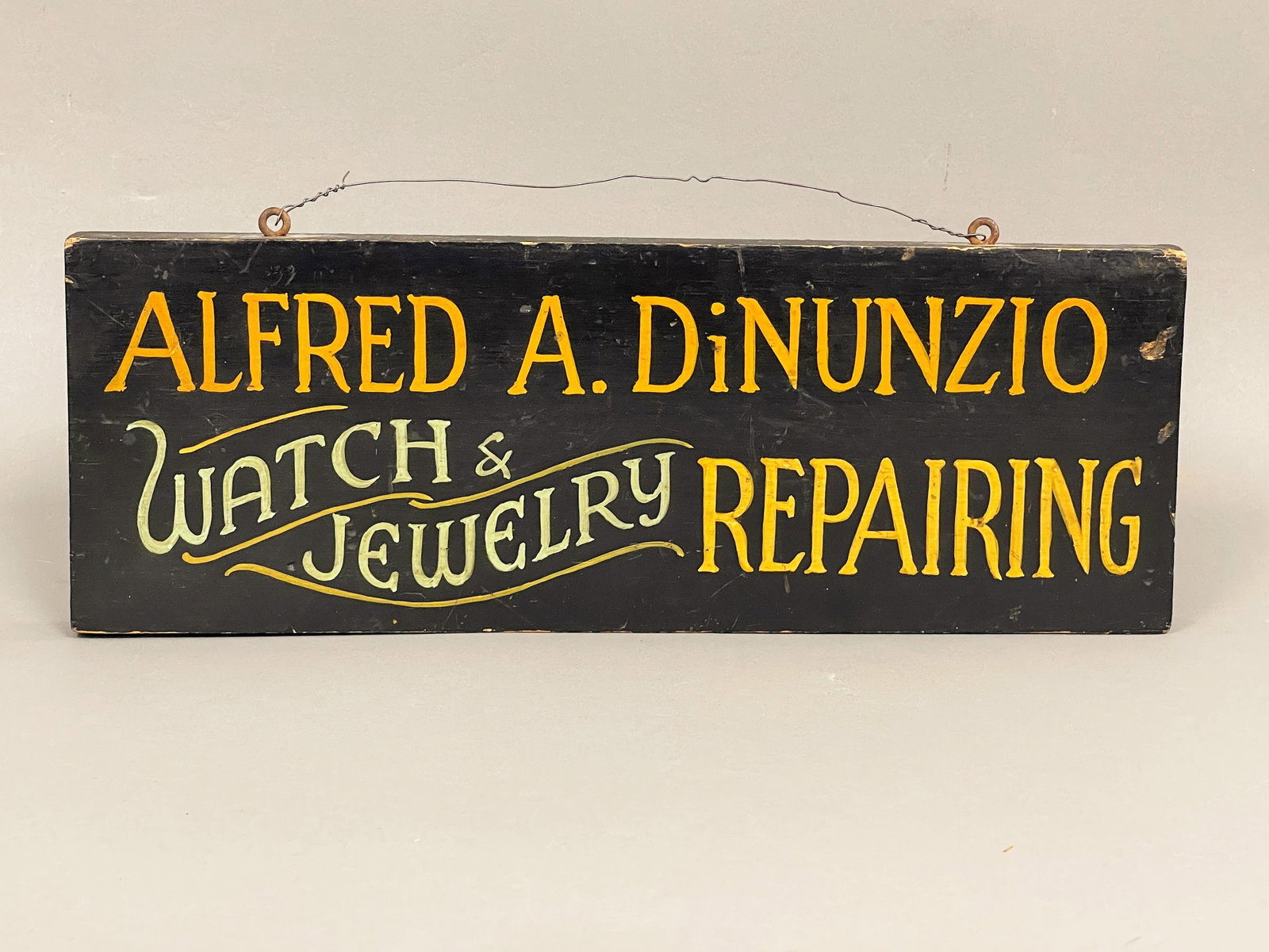 WOODEN BUSINESS SIGN " ALFRED. A. DINUNZIO WATCH AND JEWELRY REPAIRING": WOODEN BUSINESS SIGN " ALFRED. A. DINUNZIO WATCH AND JEWELRY REPAIRING" 5" X 14"