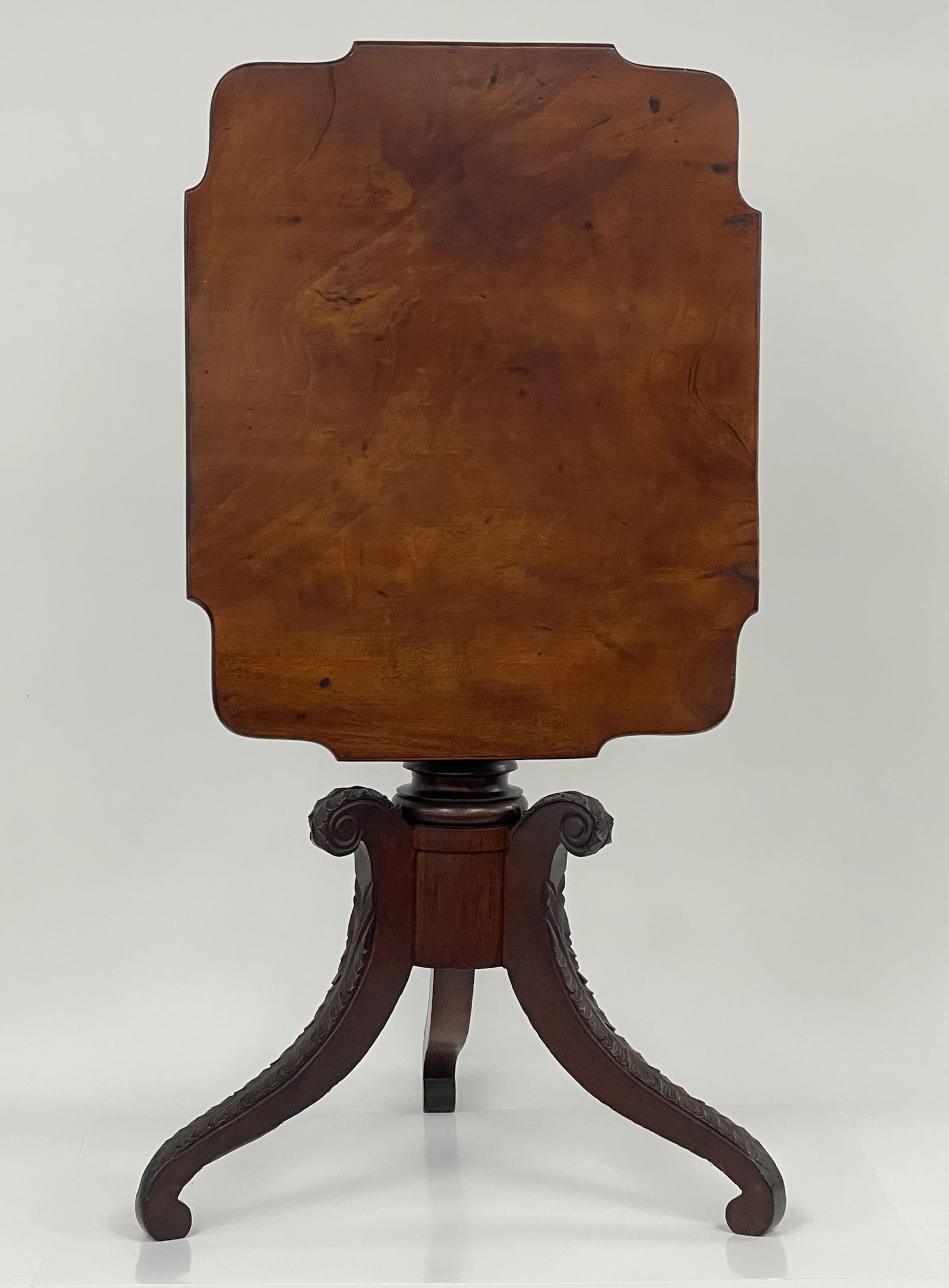 AMERICAN CLASSICAL CARVED MAHOGANY TILT-TOP STAND: AMERICAN CLASSICAL CARVED MAHOGANY TILT-TOP STAND. Early-19th century in the manner of Duncan Phyfe. (New York or Philadelphia). Highly figured one-board top with impressive carved pedestal and extens