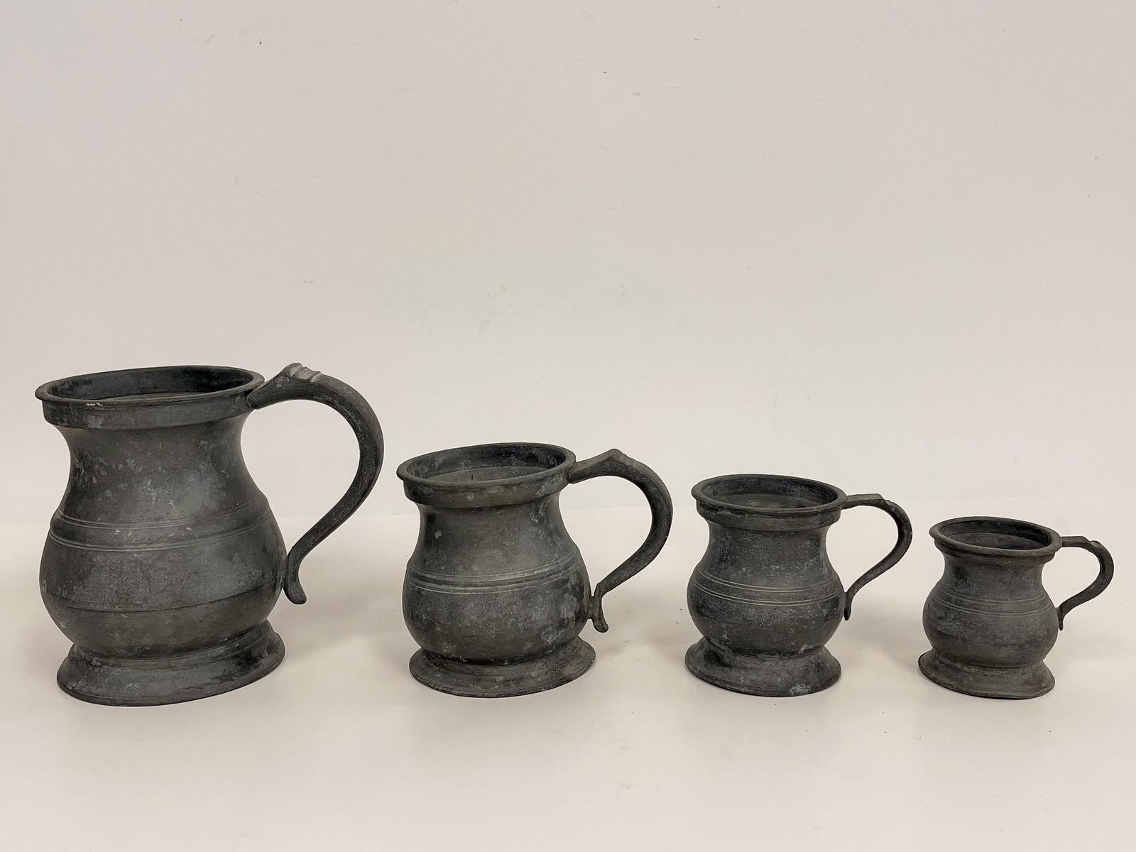 FIVE PEWTER HANDLED MEASURING TANKARDS (1 of 4)