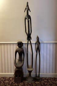 THREE TALL CARVED TRIBAL FIGURES ONE ON METAL BASE