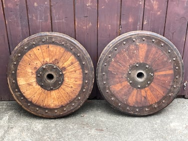 PAIR OF WELL-WORN IRON MOUNTED SOLID WOOD WHEELS