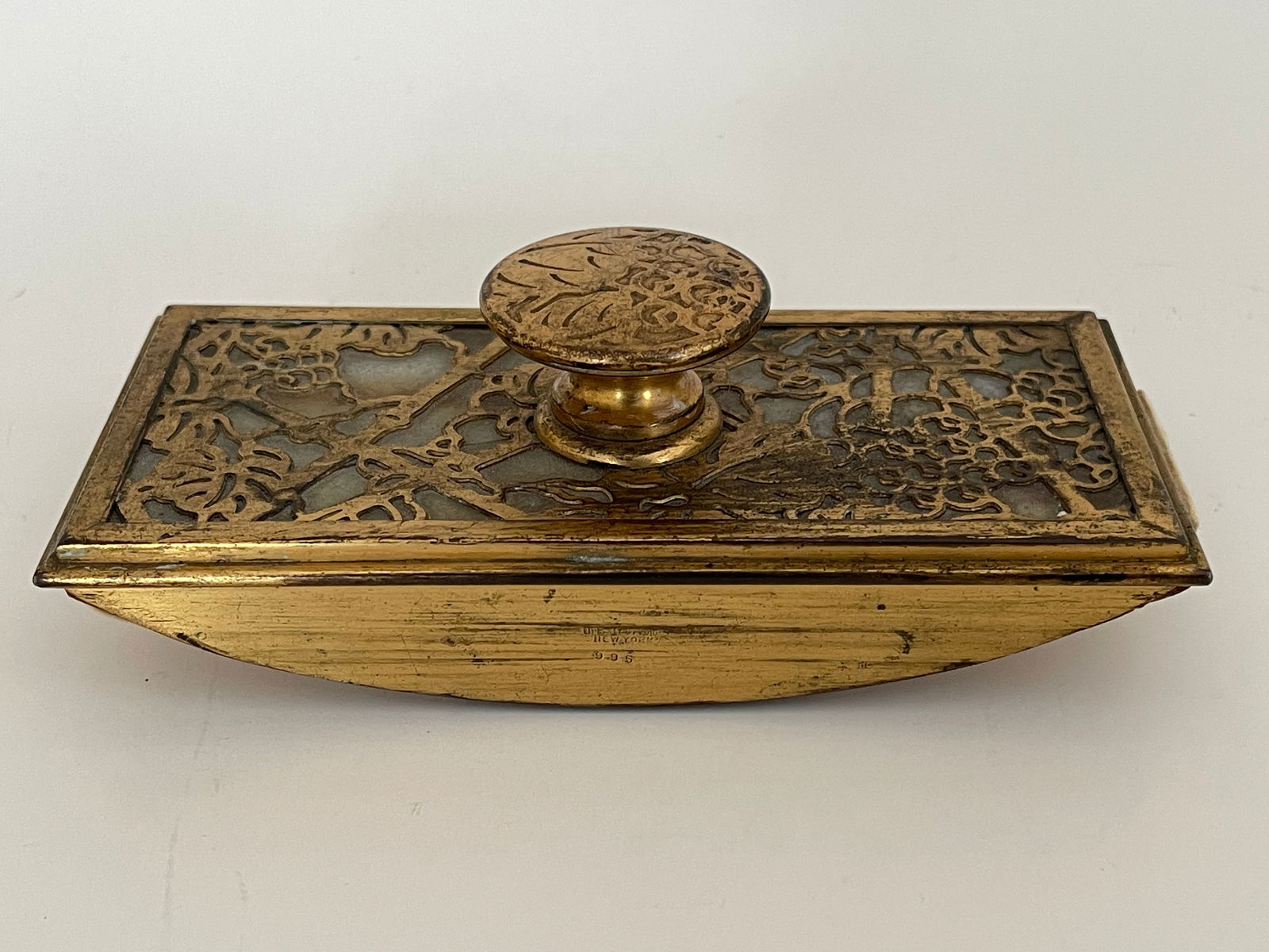 A TIFFANY STUDIOS ART NOUVEAU INK BLOTTER: A TIFFANY STUDIOS ART NOUVEAU GOLD DORÉ ROCKER INK BLOTTER WITH GRAPE LEAF PATTERN OVER SLAG GLASS. STAMPED TIFFANY STUDIOS, NEW YORK 995 ON SIDE. 2 1/2" TALL X 6" WIDE