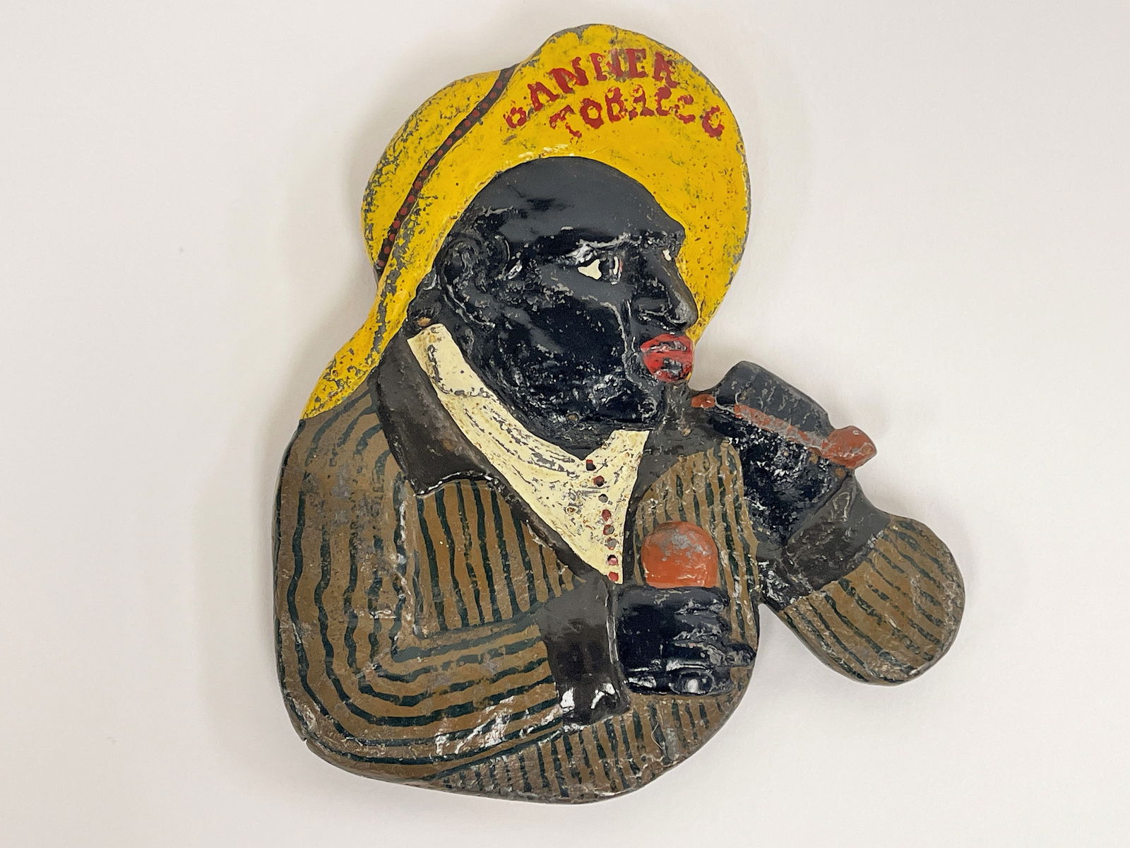 BANNER TOBACCO PLAQUE: BANNER TOBACCO PLAQUE Half round cast iron figure, vibrant original paint, excellent condition.