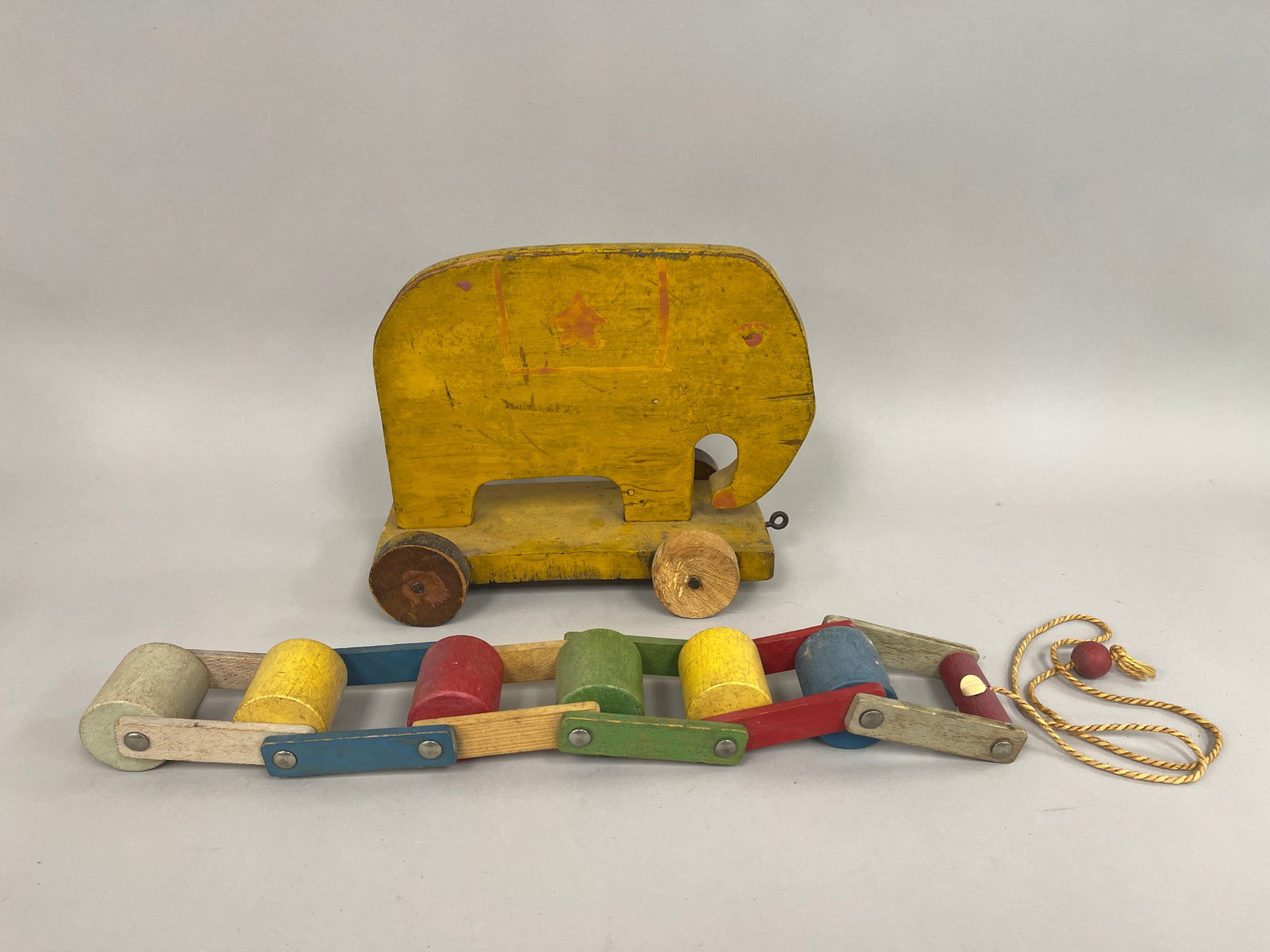 ROLLERS & ELEPHANT PULL TOYS: ROLLERS & ELEPHANT PULL TOYS Original paint, wood, yellow elephant on base, multi-colored rollers pull toy, C 1920’s, excellent condition.