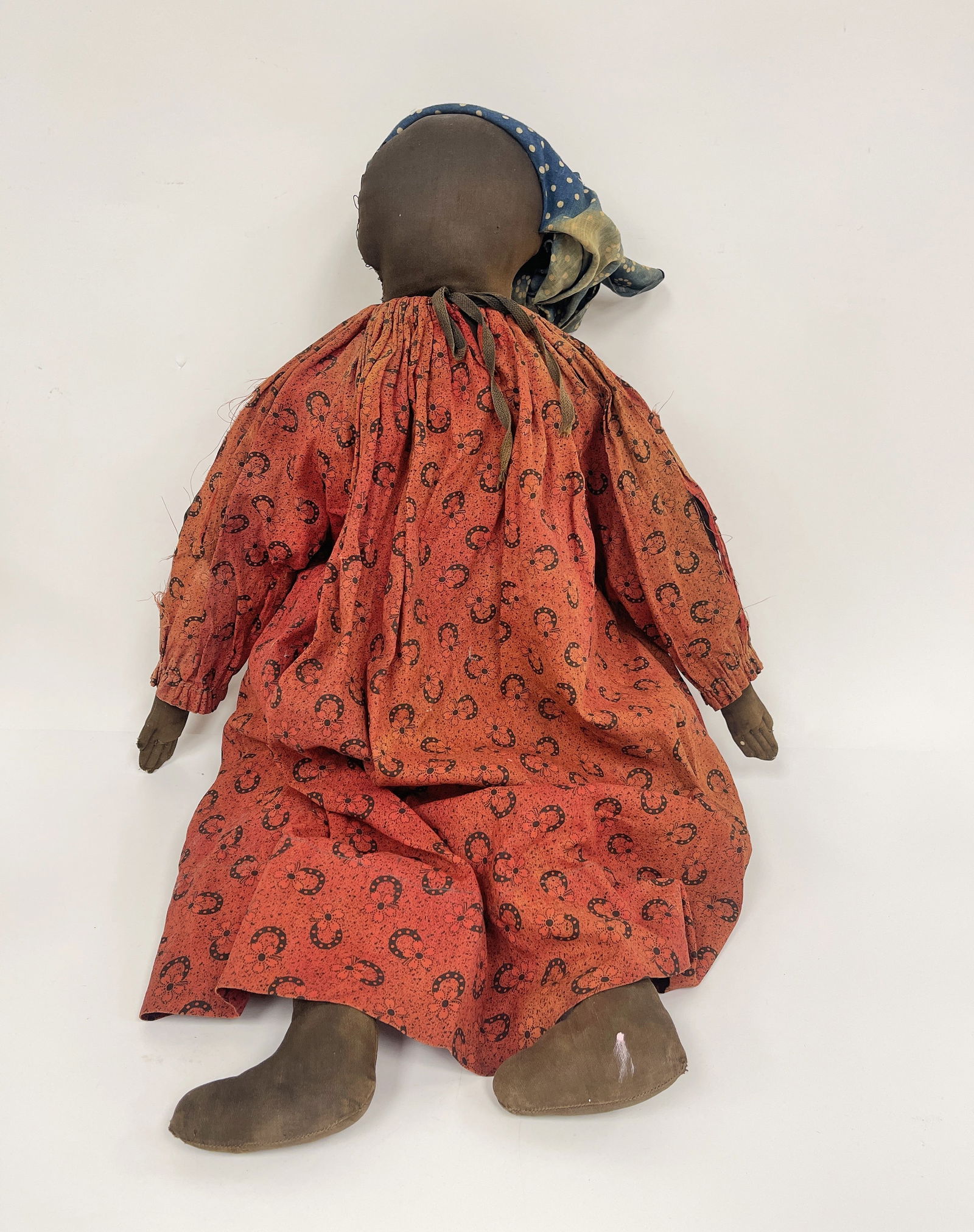 BLACK DOLL: BLACK DOLL Fabric stuffed, painted face, leather hands, red dress, late 19th – early 20th C.