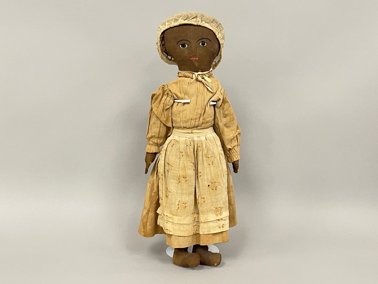 BLACK DOLL, TAN DRESS: BLACK DOLL, TAN DRESS Fabric stuffed, embroidered face, late 19th – early 20th C.