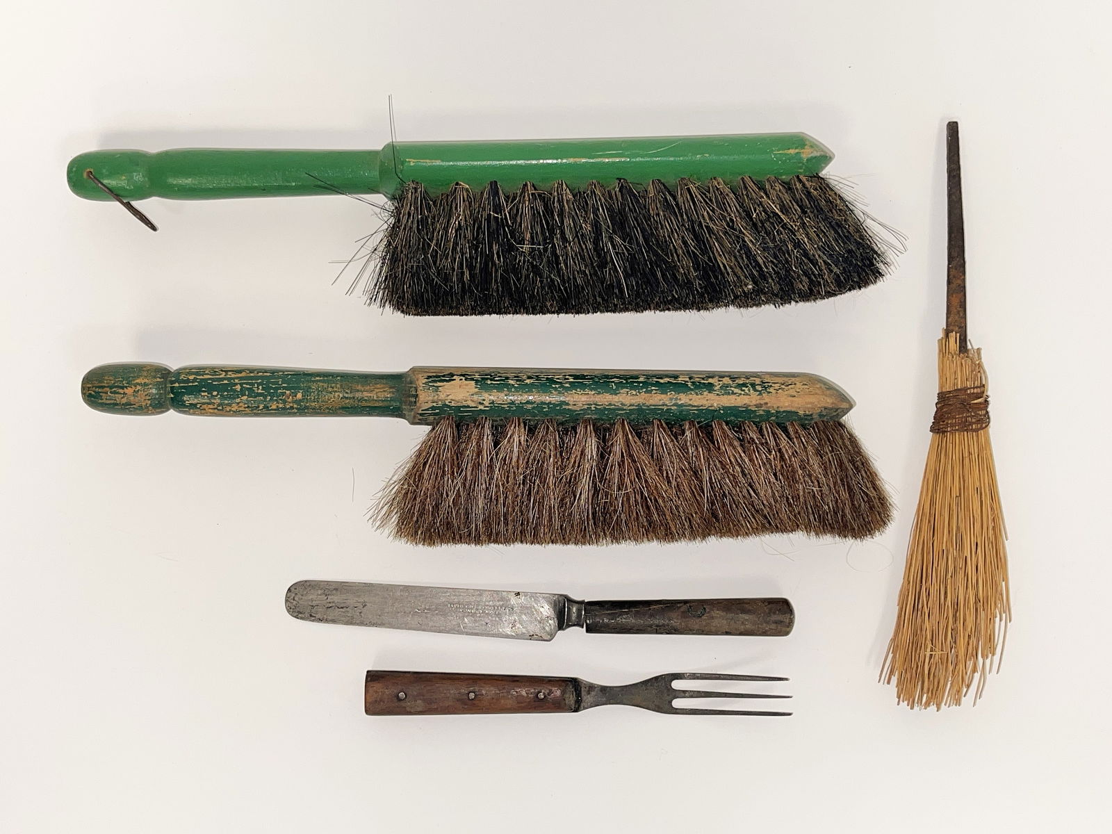 GROUP OF THREE EARLY BRUSHES & CUTLERY: GROUP OF THREE EARLY BRUSHES & CUTLERY 18th C miniature straw whisk broom with tapered forged iron handle, together with two green painted 19th C horsehair brushes & early wood handled knife & fork.