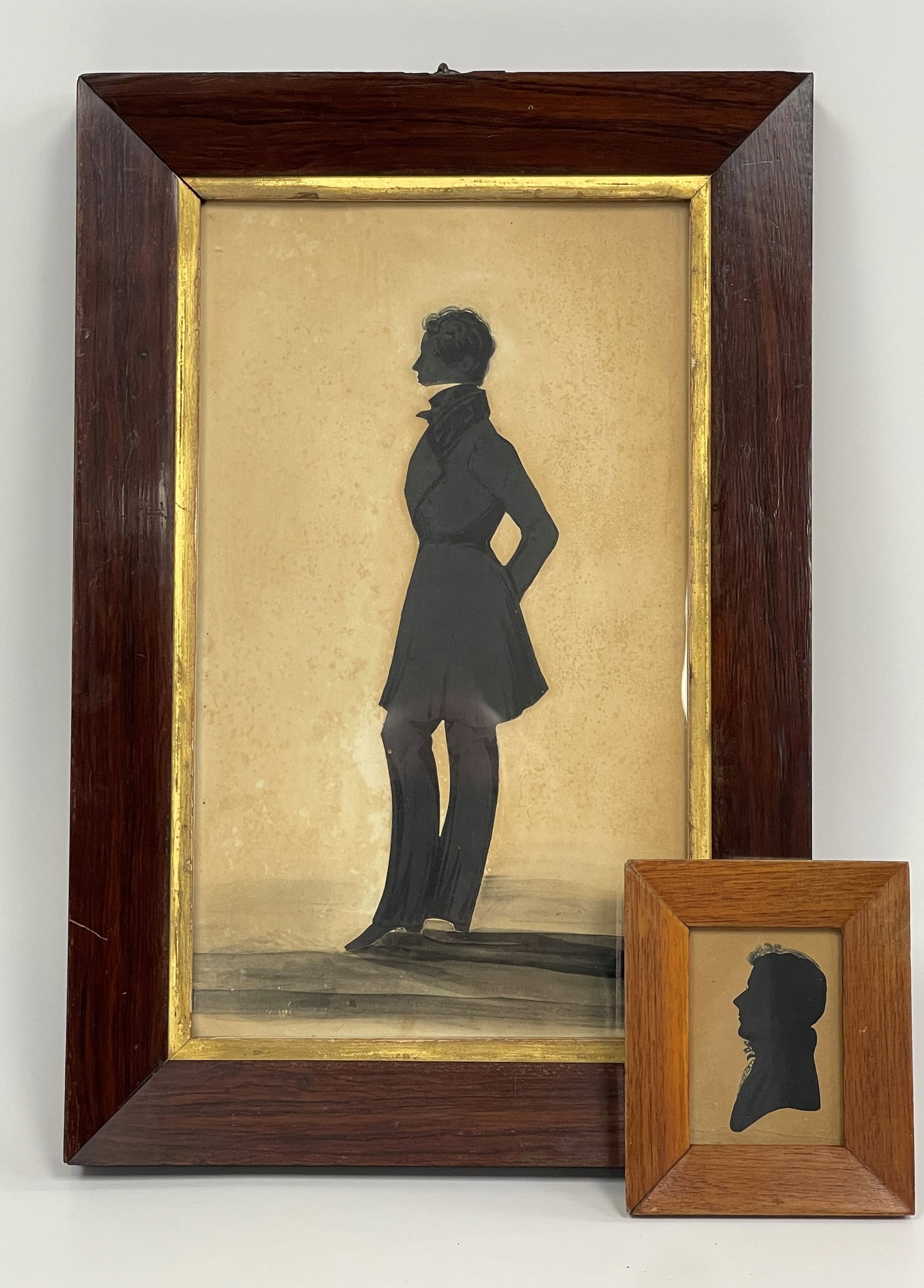 TWO 19TH C FRAMED SILHOUETTES: A.C1820 LARGE HOLLOW CUT SILHOUETTE MAN FACING LEFT WITH PAINTED CLOTHING AND PEN EMBELLISHMENTS OF HAIR IN 19TH C FRAME/GLASS B.C1833 CUT SILHOUETTE OF JACOB CREMER WITH PEN EMBELLISH HAIR 10 X 15,