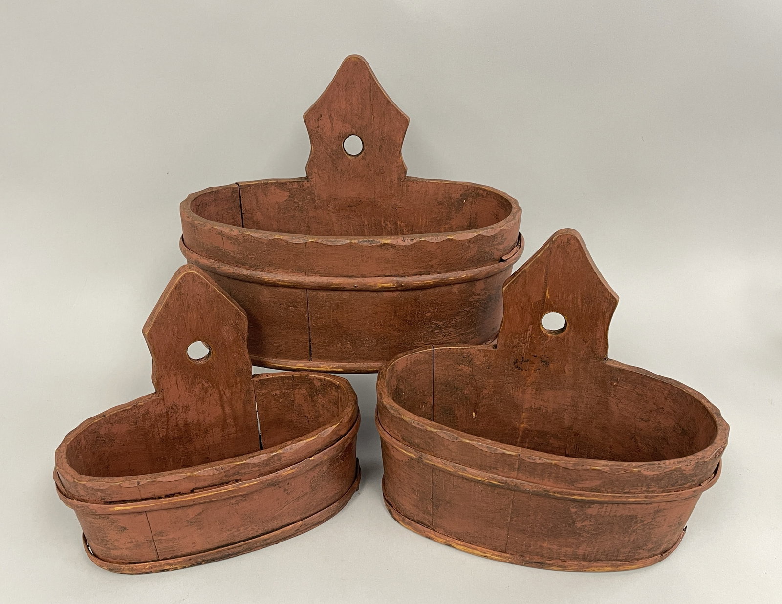 GRADUATED SET OF 3 HANGING OVAL WOOD CARRIES IN RED: GRADUATED SET OF 3 HANGING OVAL WOOD CARRIES IN RED 7" X 13" , 6" X 11" , 5" X 10"