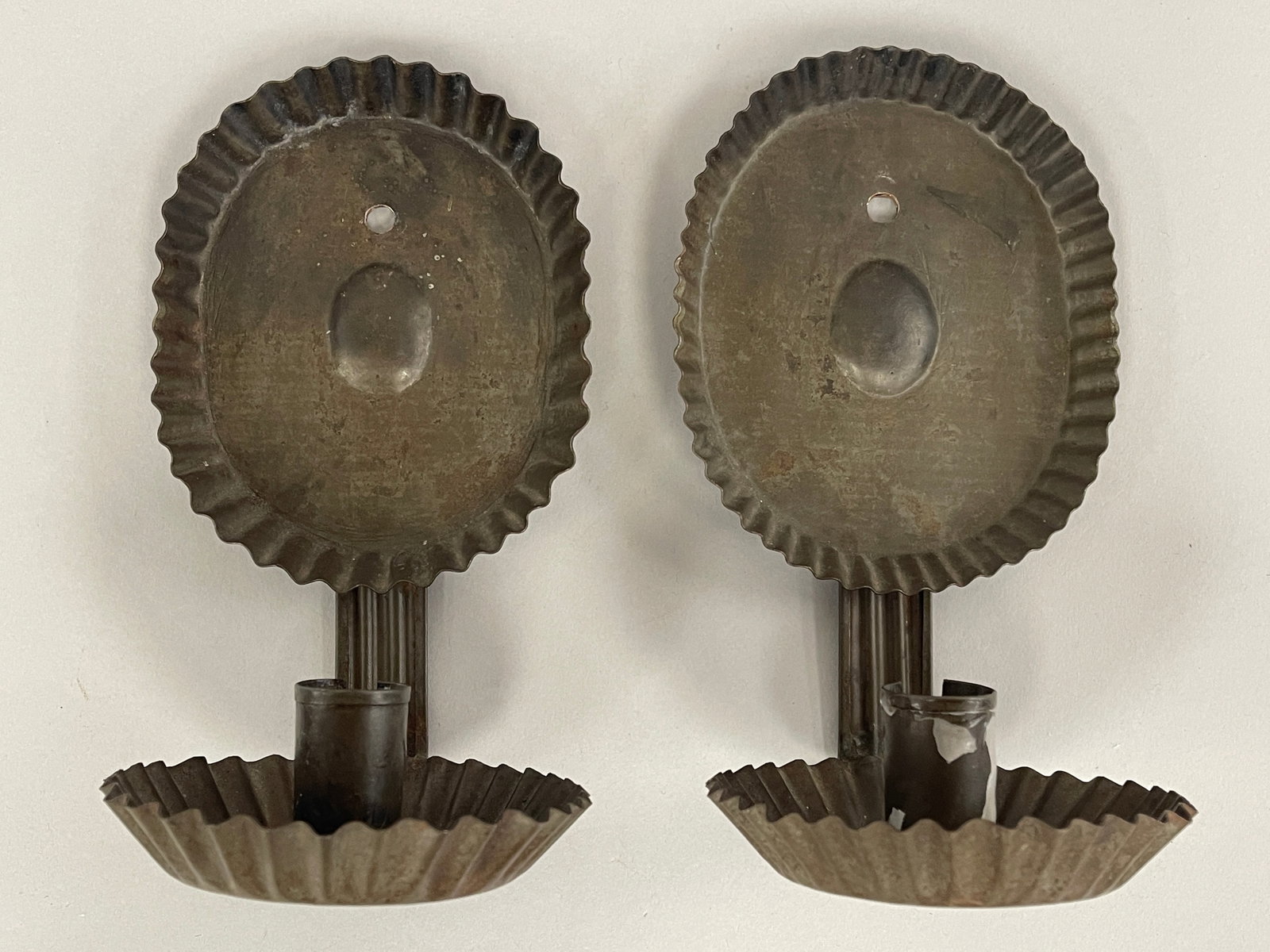 RARE SMALL OVAL SCONCES C 1780-1820: RARE SMALL OVAL SCONCES C 1780-1820, ROLLED SHEET IRON, EX; MUSEUM COLLECTION. PIECRUST CRIMPED OVAL BACKPLATES WITH OVAL RAISED CENTER MEDALLION, CONFORMING DEEP DRIP TRAYS, FOLDED EDGE, SLOTTED