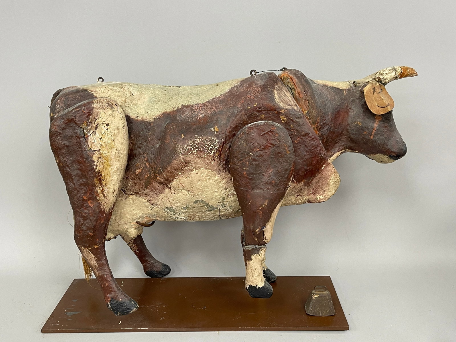 ARTICULATED COW: ARTICULATED COW C 1900, PAINTED PAPIER MACHE BODY, PROBABLY MADE AS A PUPPET SHOW ELEMENT, MOUNTED ON MUSEUM STAND