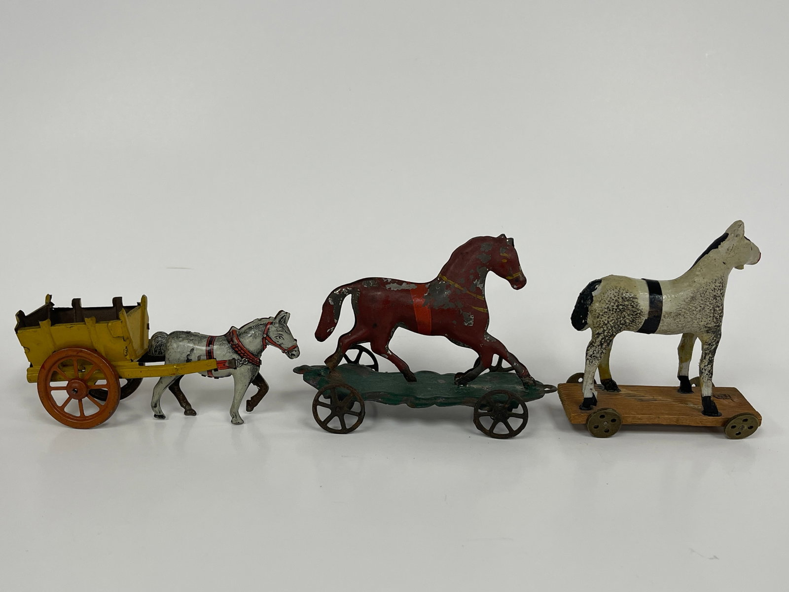 3 SMALL HORSE PULL TOYS: 3 SMALL HORSE PULL TOYS 19TH C, 2 PRESSED STEEL, 1 COMPOSITION ON WOOD PLATFORM