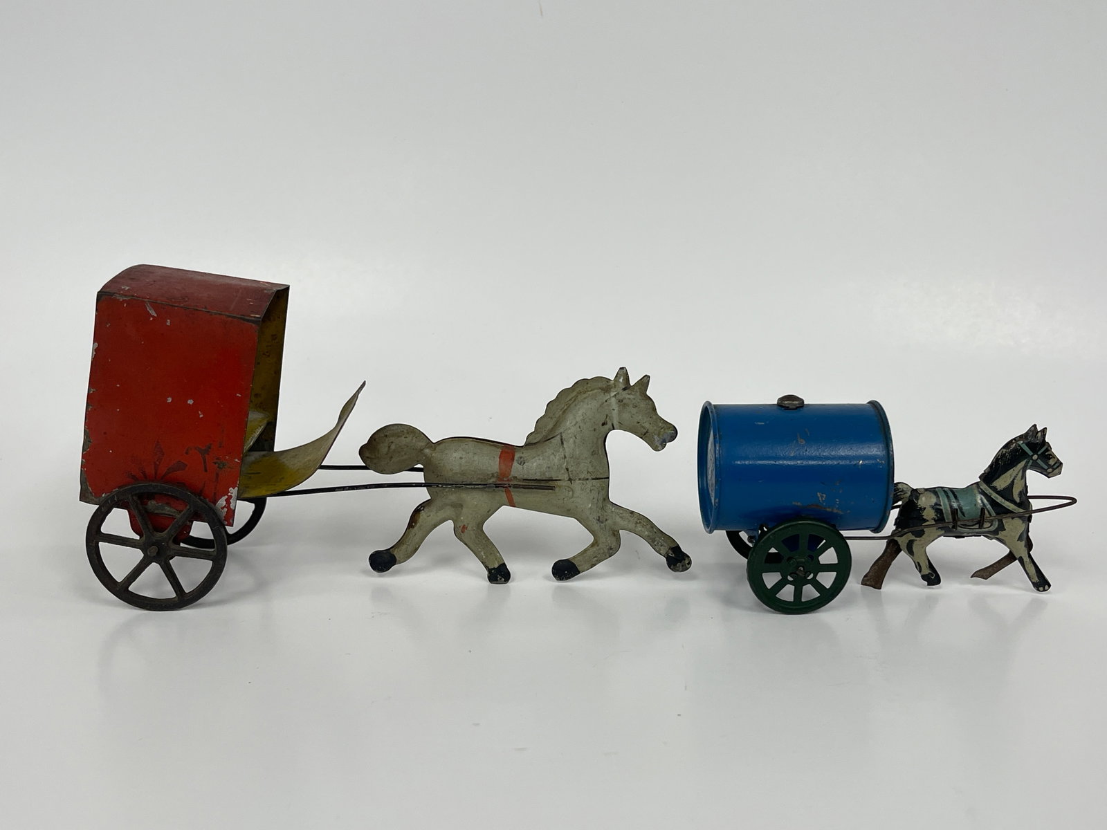 2 HORSE PULLED CART TOYS: 2 HORSE PULLED CART TOYS LATE 19TH C, PRESSED STEEL. ONE; HORSE CARRYING FLAG WITH RED & YELLOW OPENCART. TWO; HORSE PULLING YELLOW & BLUE COVERED TROLLEY. BOTH EXCELLENT CONDITION.