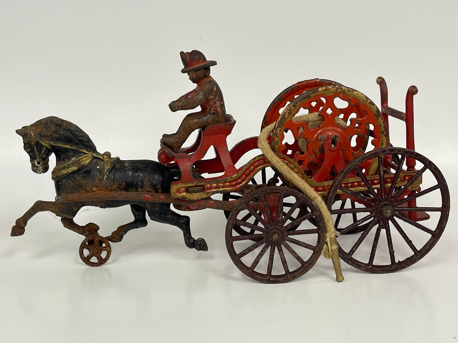 HOSE REEL FIRE WAGON TOY: HOSE REEL FIRE WAGON TOY LATE 19TH C, CAST IRON & COTTON, EXCELLENT CONDITION