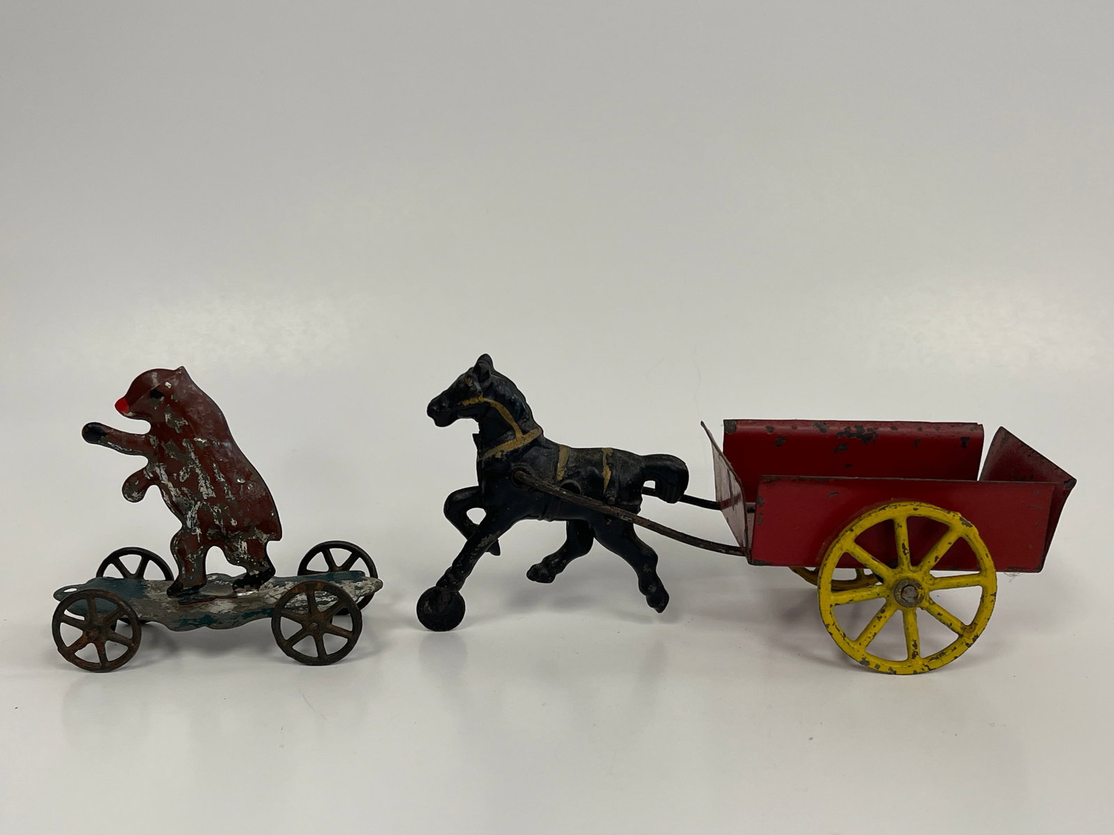 2 SMALL WHEELED TOYS: 2 SMALL WHEELED TOYS LATE 19TH C, CAST IRON & PRESSED STEEL. HORSE DRAWN RED CART & BEAR ON WHEELED GREEN PLATFORM. VG CONDITION.