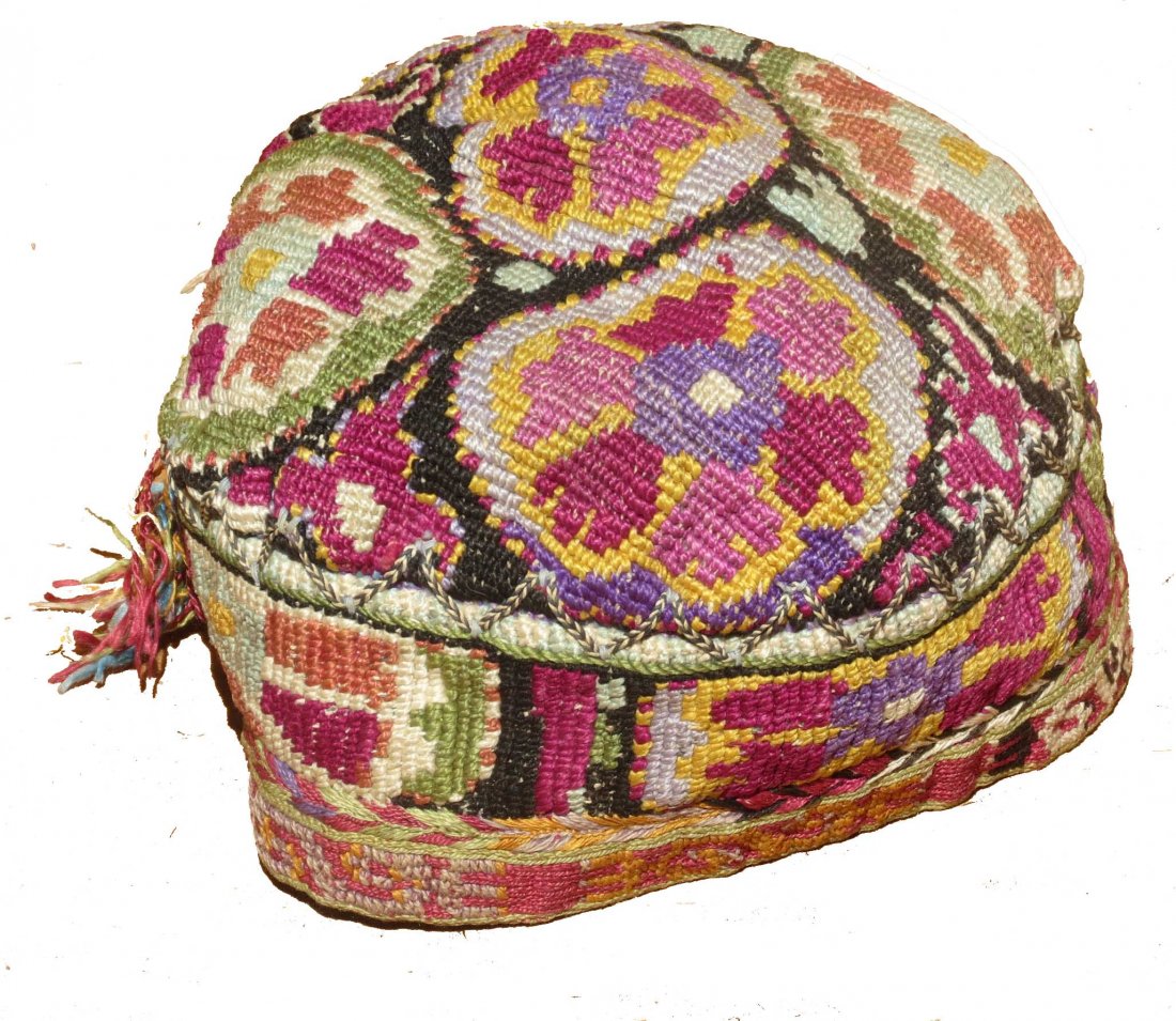 Uzbek Embroidered Hat, circa 1900: A fully embroidered hat from Central Asia, probably Uzbek. The purple dye is undoubtedly synthetic, while the other colors are probably derived from natural dyes.It consists of silk embroidery on a li