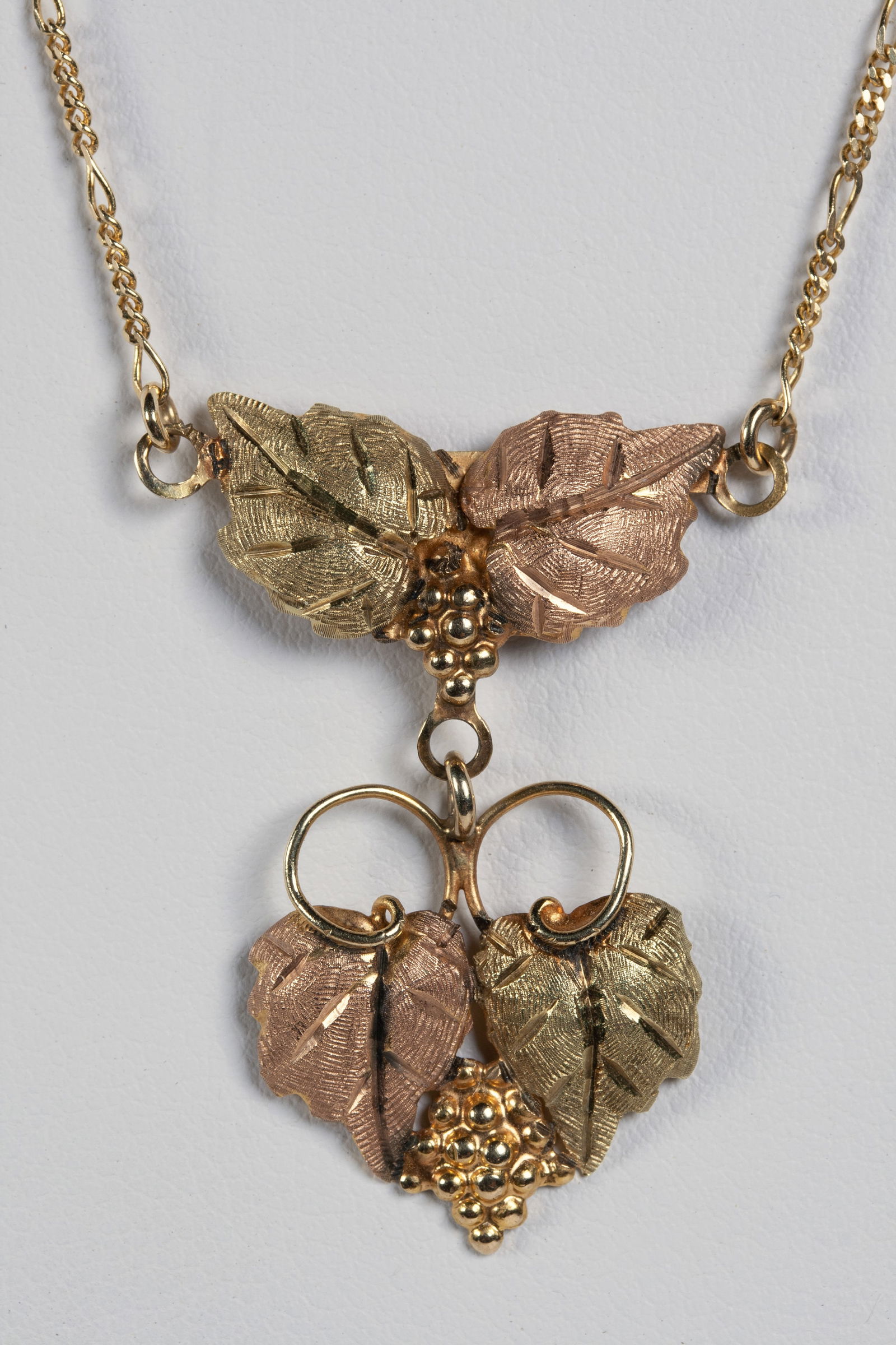 Black Hills Gold Necklace and Earrings: Black Hills Gold Jewelry Co. necklace and matching earrings in the original box. Grapes Lariat Pendant design in rose and yellow gold. Circa 1950s - 1960s. Signed on the back of the necklace "Black Hi