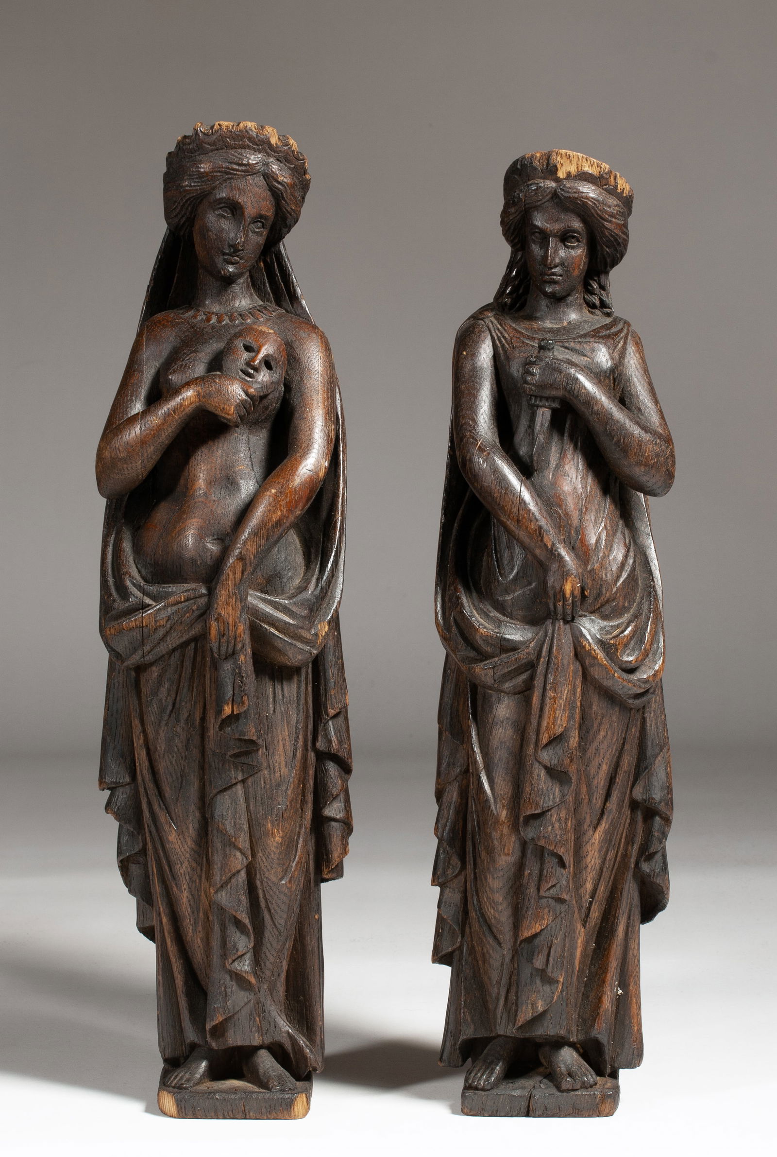 Comedy & Tragedy 18th - 19th Century - Carved Wood Classical Figures: Pair of beautifully carved Greek mythology figures possibly representing comedy and tragedy. Carved in the round. One holding a mask and one holding a dagger or knife. Both women depicted in ancient C