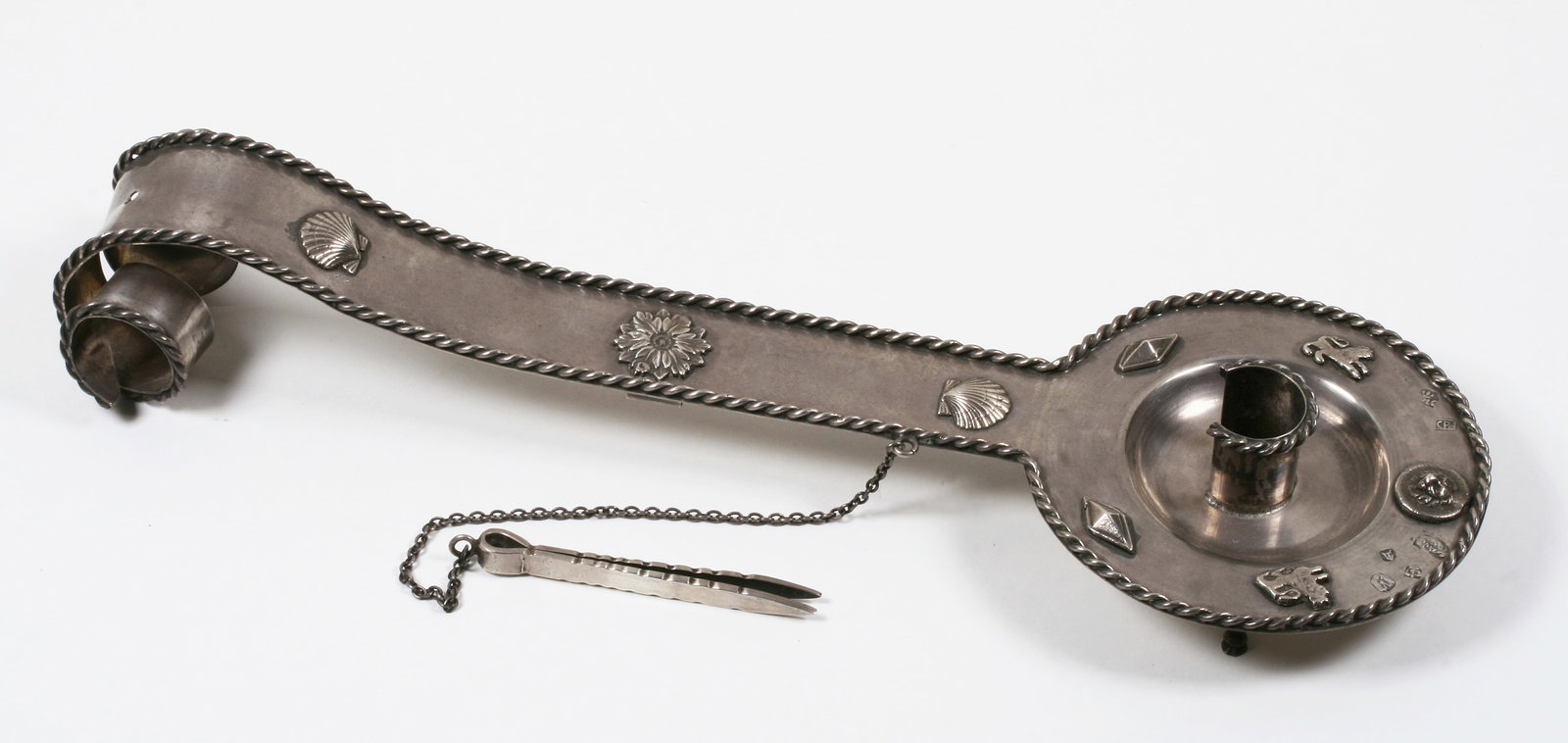 Antique Silver Chamberstick with Hallmarks: Spanish or Spanish Colonial style footed chamberstick. Tests as 900 silver. A footed bowl with a long flat handle terminating in a curled, bi-furcated end. The feet in the front are in the shape of an