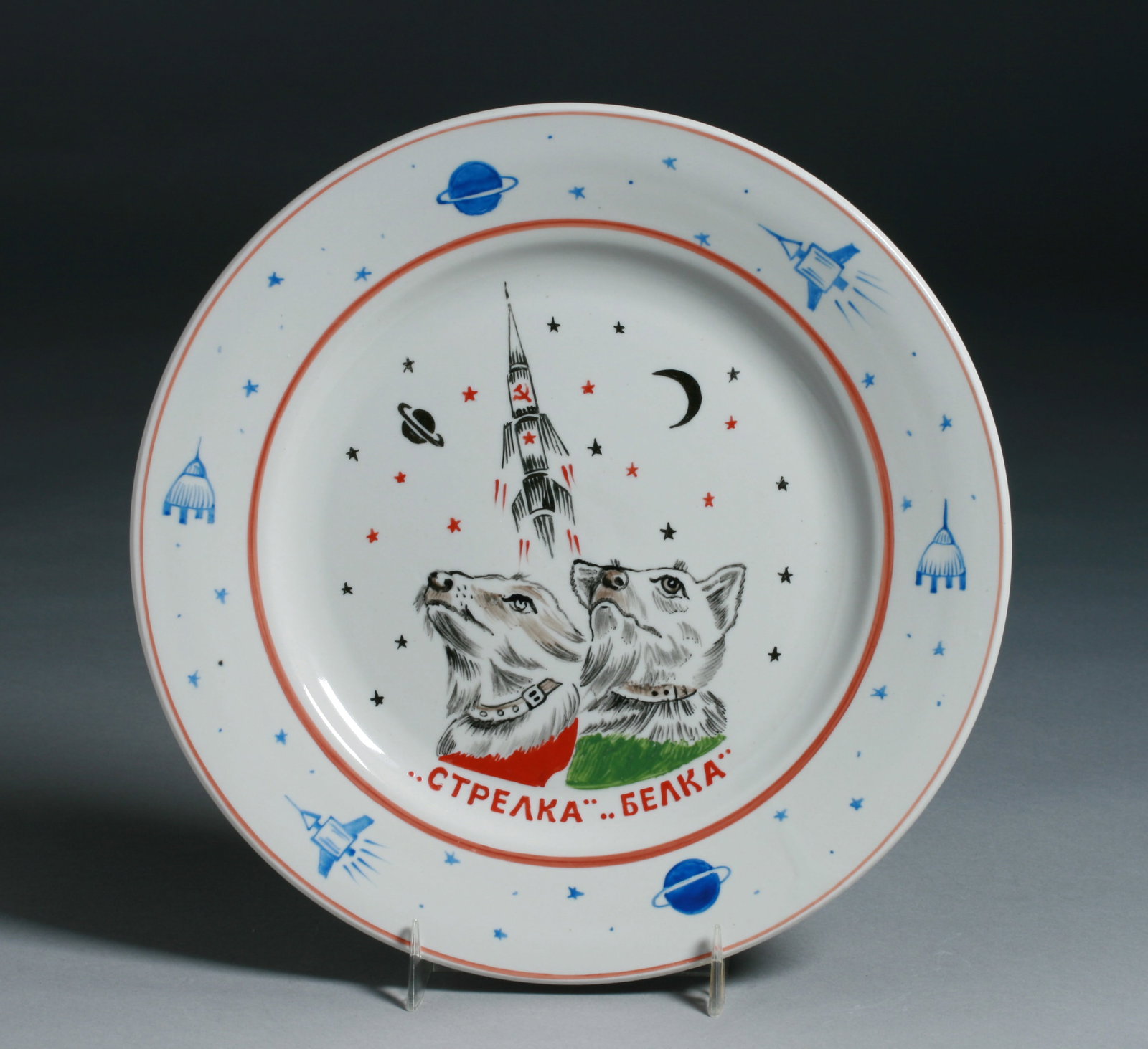 Soviet Russian Hand-Painted Porcelain Plate - Space Dogs Strelka & Belka: A fine Russian hand-painted and glazed porcelain memorial plate depicting the Soviet space dogs Strelka & Belka. Circa 1970's. The two were launched into space in Sputnik 5 on August 19, 1960. Dedicat