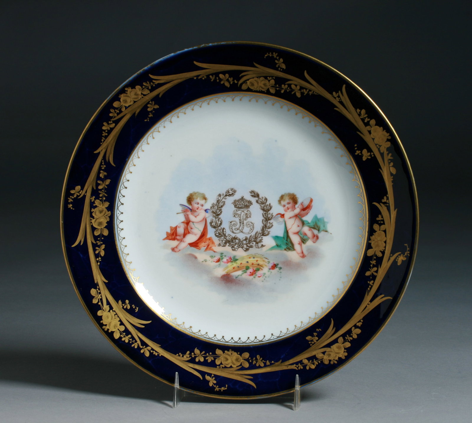 Sevres Hand-Painted Porcelain Plate - Cherubs - King Louis Philippe: A French porcelain plate by Sevres. 19th Century. The plate is superbly hand painted with two cherubs flanking the King's LP initials in gold, under a crown with a leaf wreath around them. The Cherubs