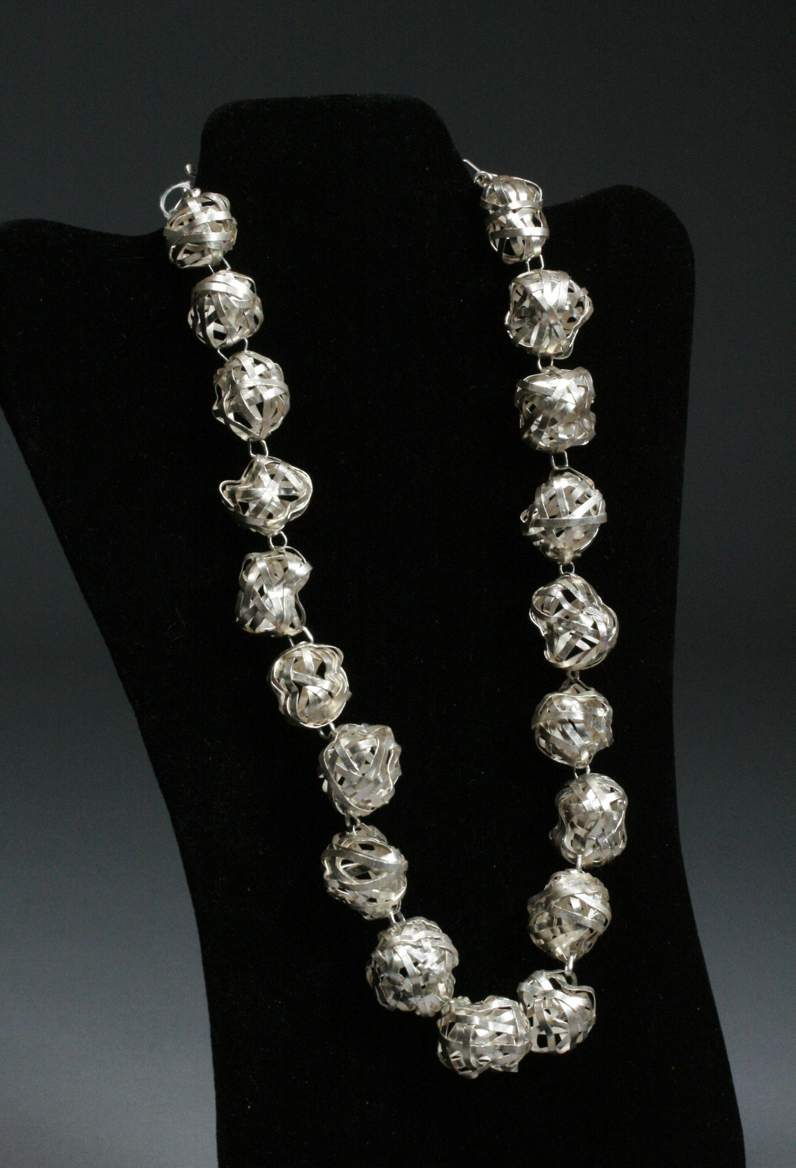 Brutalist Modernist Sterling Woven Cage Ball Necklace - Signed: A sterling silver designer necklace. 20th Century. Signed with a round spiral hallmark on a tab near the wire clasp. With a vintage price tag attached. Maker unknown. A finely crafted, chunky but ligh
