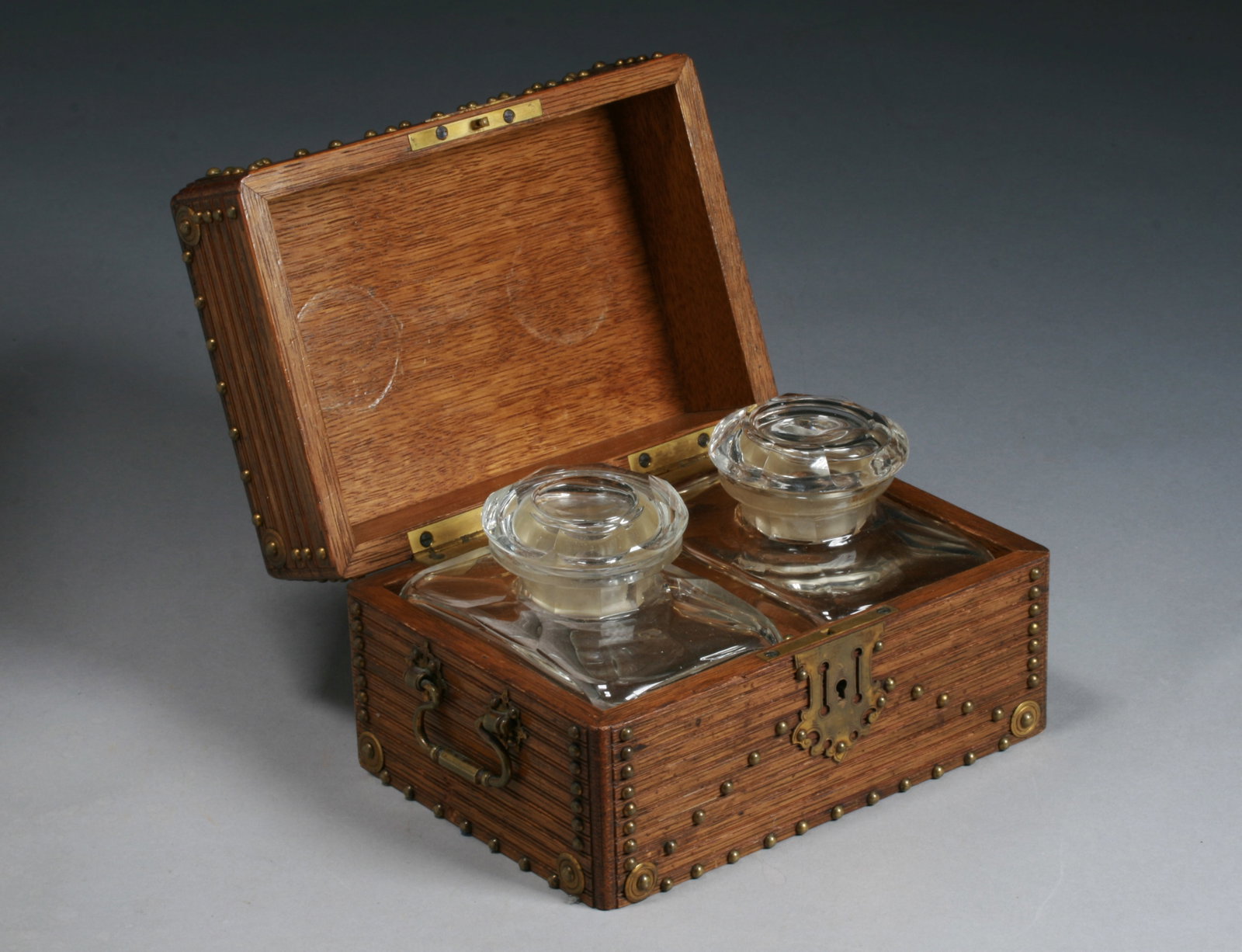 Antique French Double Perfume Box - 19th Century: A fine 19th century French double perfume box with the original Baccarat style bottles. Circa 1870's. Featuring an oak hardwood box with carved and brass studded decoration and a Limoges floral oval p