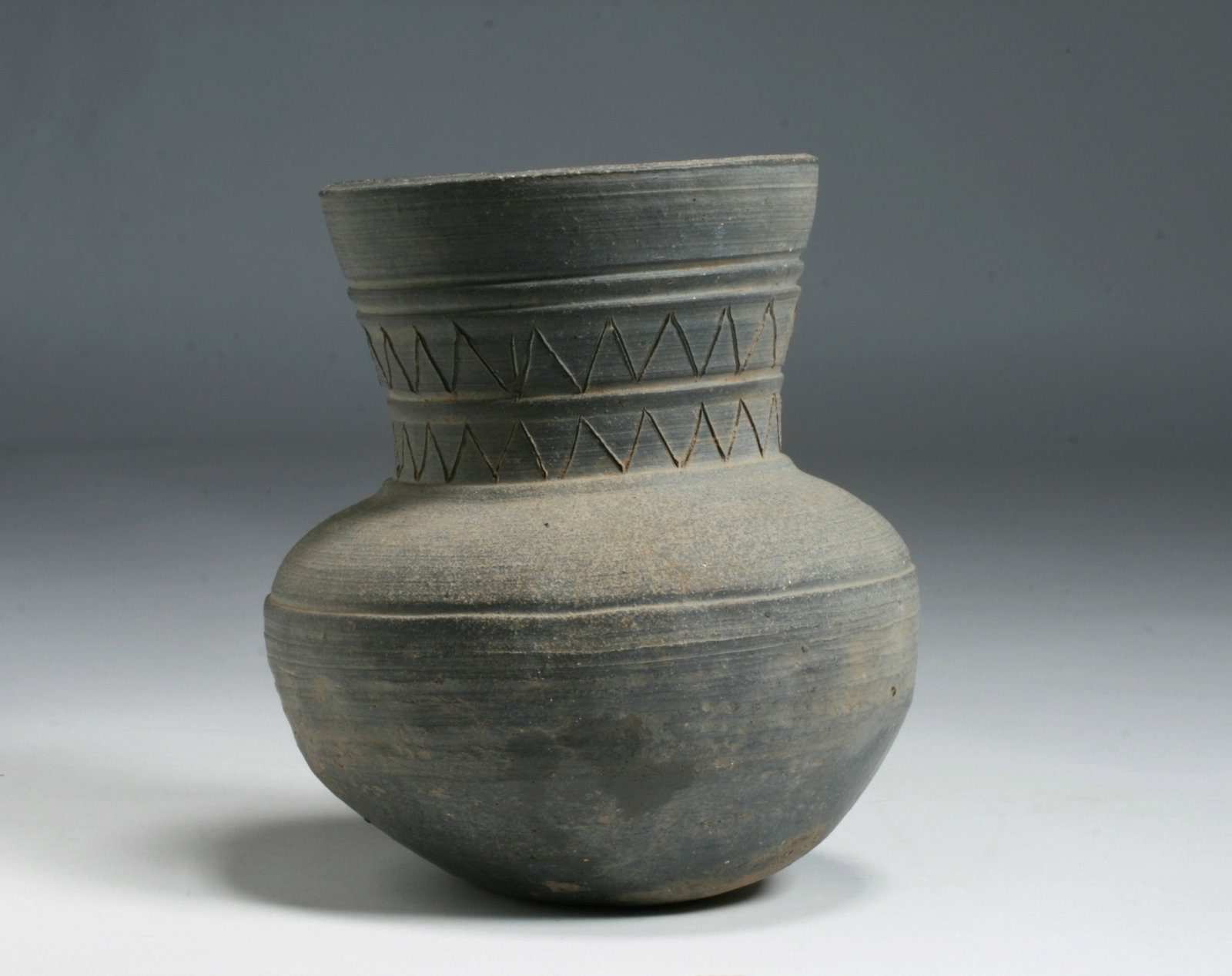 A Korean Stoneware Storage Jar - Silla Dynasty 5th / 6th Century: An ancient Korean Stoneware pottery storage jar, hand-thrown and decorated with incised designs on the outside. Silla Dynasty 5th / 6th Century. Collector's numbers written on the bottom. Height : 6 3