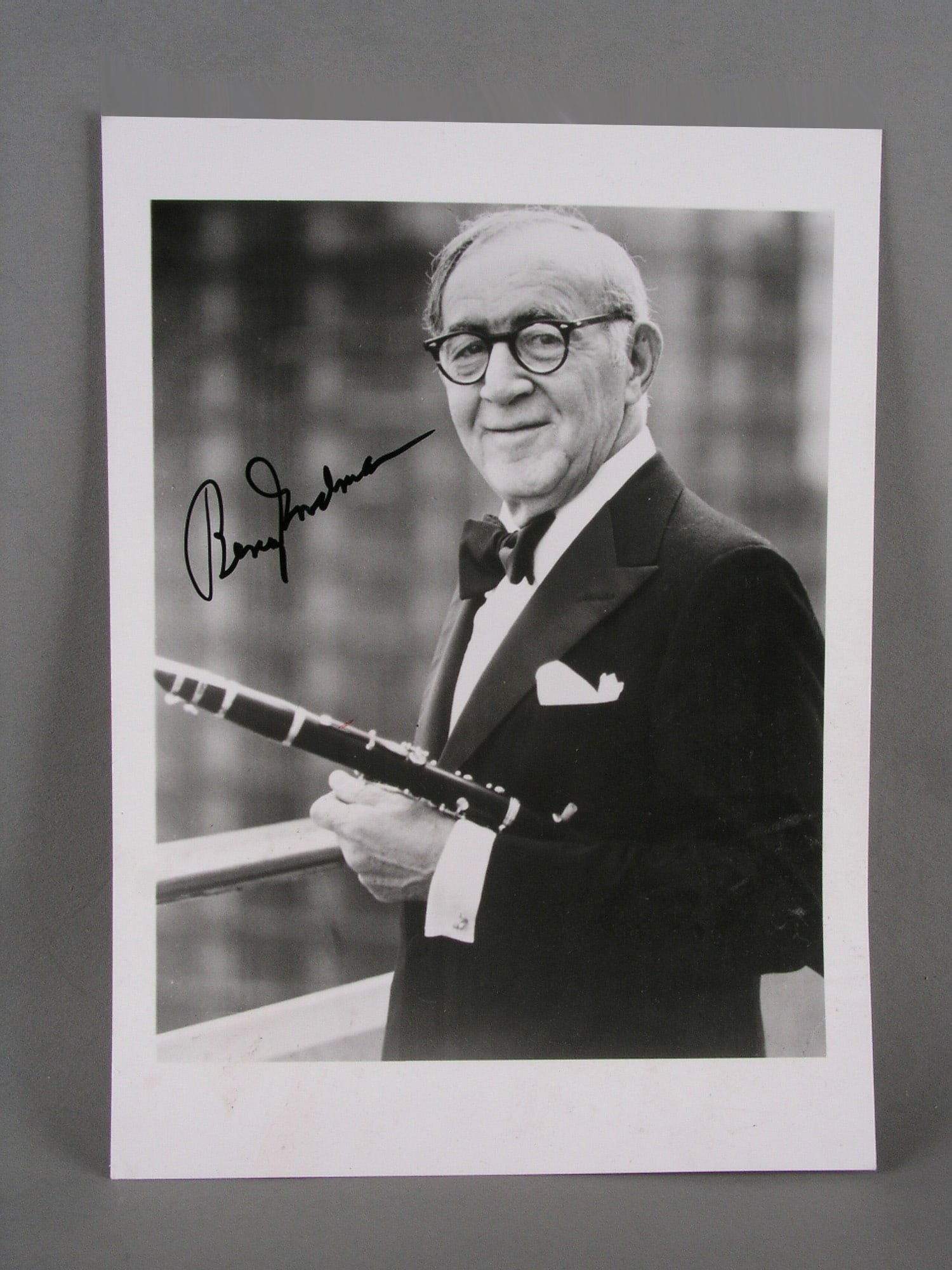 Autographed Signed Photograph - Benny Goodman with Clarinet: Small black and white silver-gelatin photograph of musician Benny Goodman in his later years. He is depicted wearing a tuxedo and holding his beloved clarinet. The image is autographed by Benny