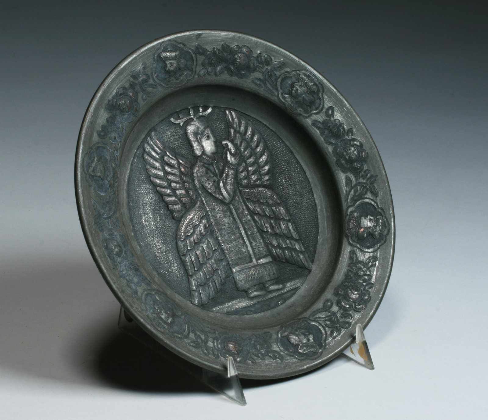 Antique Persian Engraved Copper Bowl - Qajar Dynasty: A beautiful Persian engraved & repousse copper bowl. Qajar Dynasty, Iran 19th century. Finely decorated with an Angel with wings holding a fruit in the center area and the rim with a border of flower 