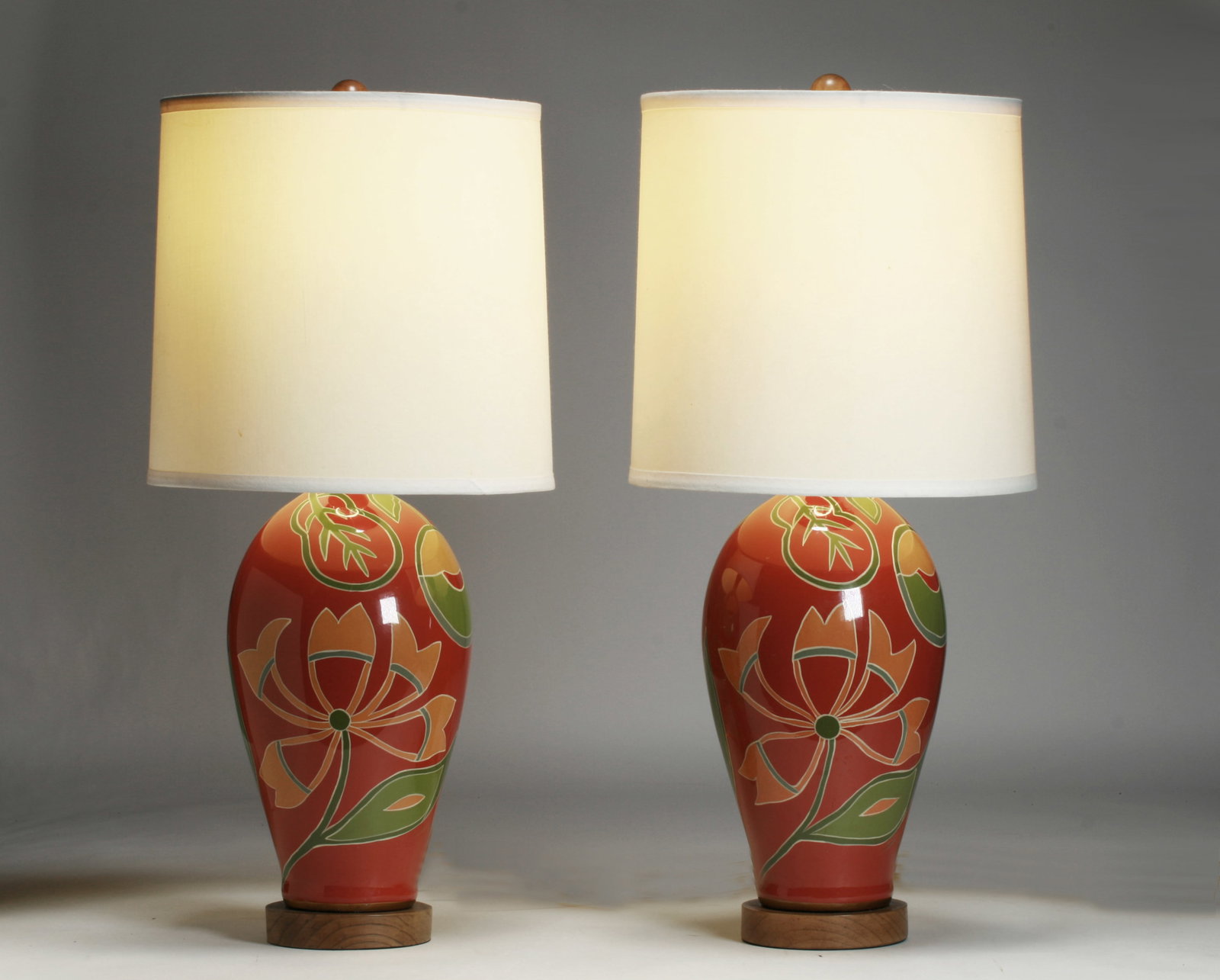 Abstract Floral Decorator Lamps by Jill Rosenwald for Toyo: A beautiful pair of hand-painted ceramic lamps designed by Jill Rosenwald for Toyo. Contemporary, circa 1990's. Abstracted floral design. Wood bases and finials. Signed on the bottom of one lamp with
