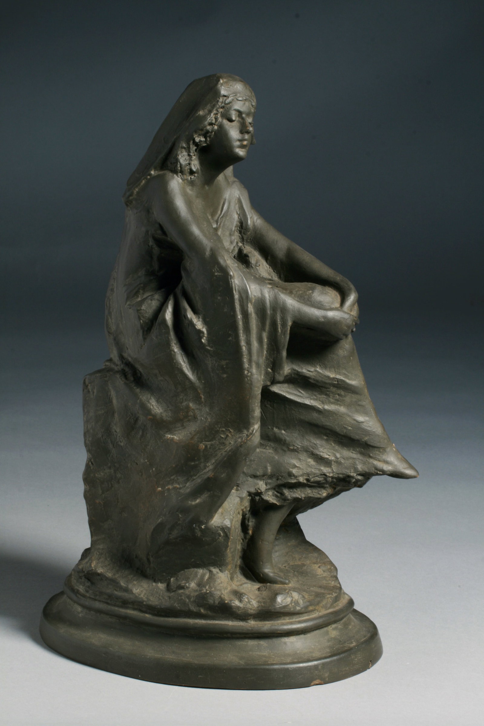 Art Nouveau Ceramic Sculpture - Signed with Monogram: A beautiful Art Nouveau ceramic sculpture of a young woman sitting in contemplation. Circa 1900. Unidentified artist. Terracotta painted to look like bronze. Signed on the back with two monograms,