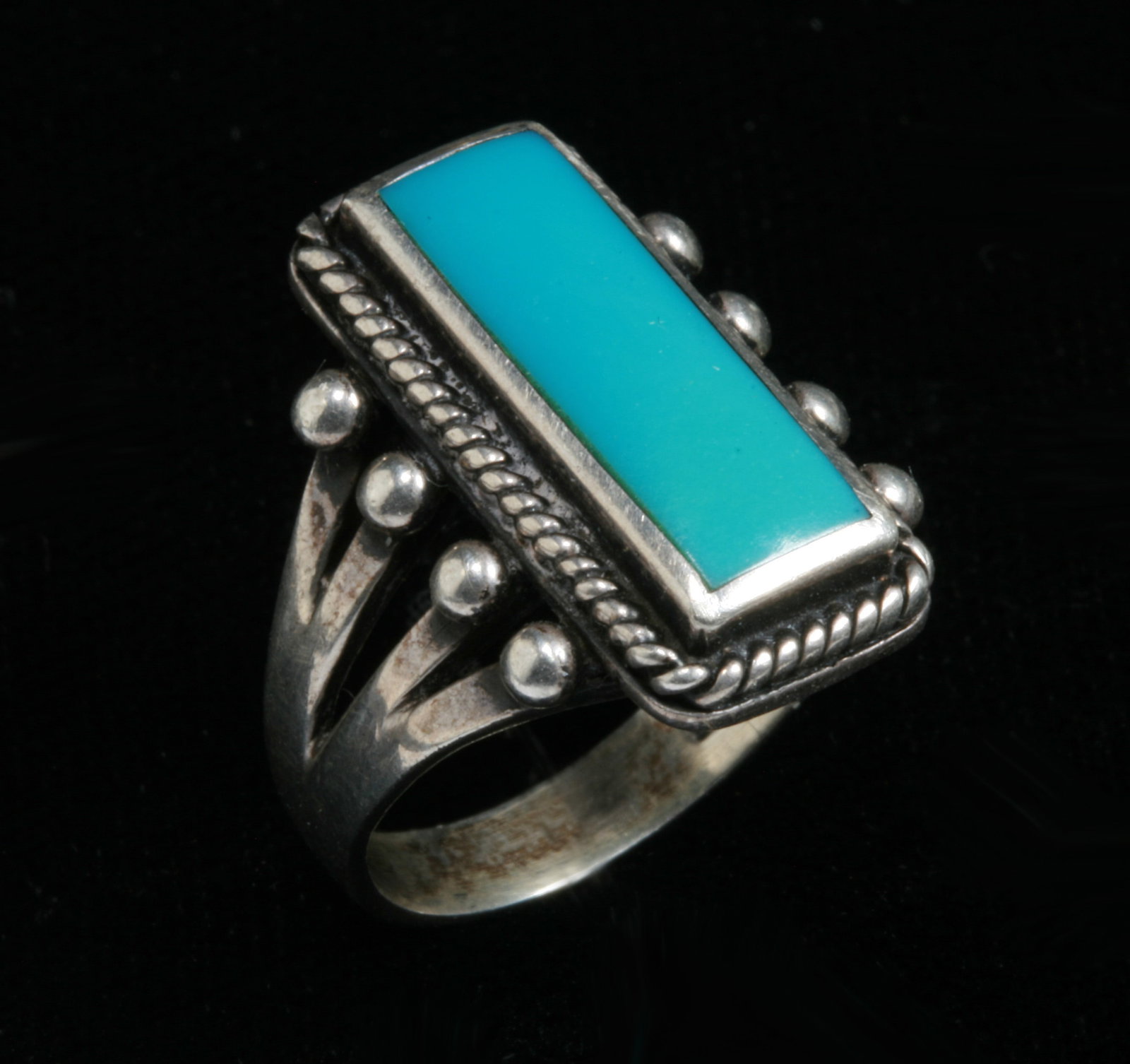Old Native American Turquoise and Sterling Ring - Marked: Old Navajo turquoise and sterling ring. Early to mid 20th century. Marked on the inside of the band (see photos). Featuring a turquoise rectangular stone surrounded by delicate twisted wire around the