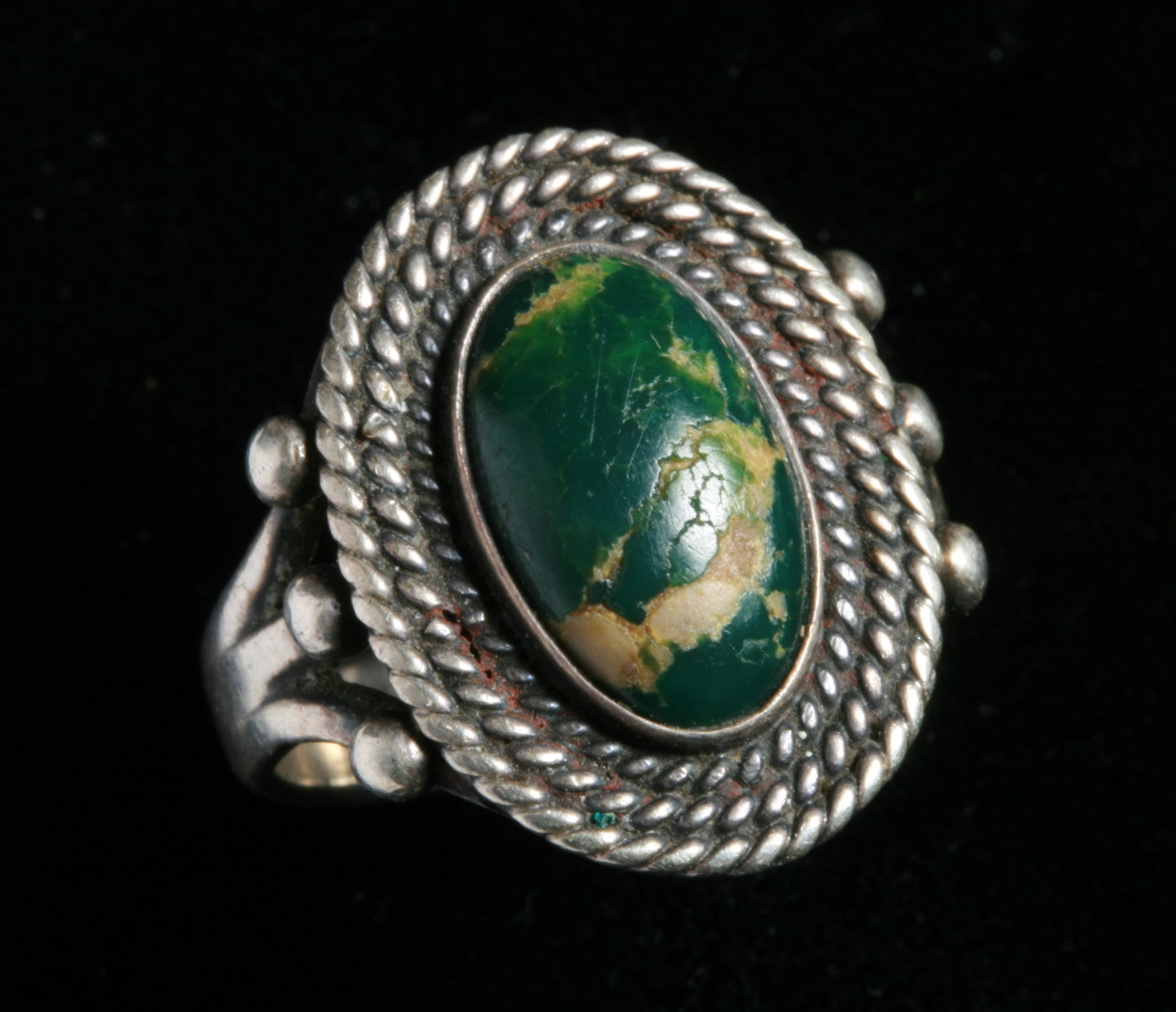 Old Navajo Native American Turquoise and Sterling Ring: Old Navajo turquoise and sterling ring. Early to mid 20th century. Unmarked. Featuring an oval, domed turquoise stone surrounded by thre layers of delicate twisted wire around the bezel and a three sh