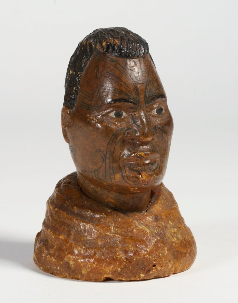Kauri Gum Bust of a Maori Chief - New Zealand, 19th C.: Rare antique Maori kauri gum carved bust from New Zealand, late 19th century. Depicts a proud Maori Chieftain with black hair, painted eyes, and intricate inked facial tattoos (Moko), wearing a feathe