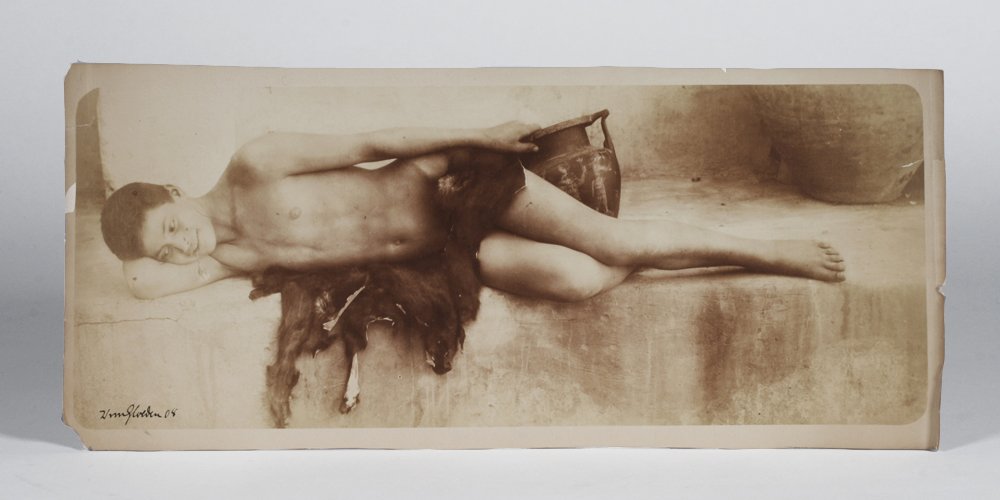 Wilhelm Von Gloeden (1856-1931) - Photograph of a Boy: Photograph of a reclining Italian boy, dressed in skins and holding an ancient Roman vase by Baron Wilhelm Von Gloeden (1856-1931). Salt print on drawing paper. Not mounted or framed. Signed and dated