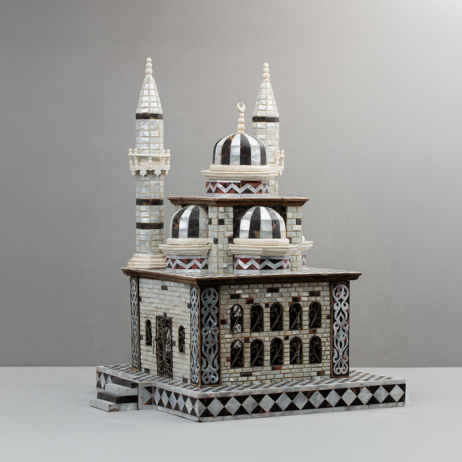 A MOTHER OF PEARL, BONE, SILVER AND TORTOISE SHELL INLAID WOODEN MINIATURE MODEL OF A MOSQUE: A MOTHER OF PEARL, BONE, SILVER AND TORTOISESHELL INLAID WOODEN MINIATURE MODEL OF AMOSQUEL: 37 - W: 40 x. H: 57 cm