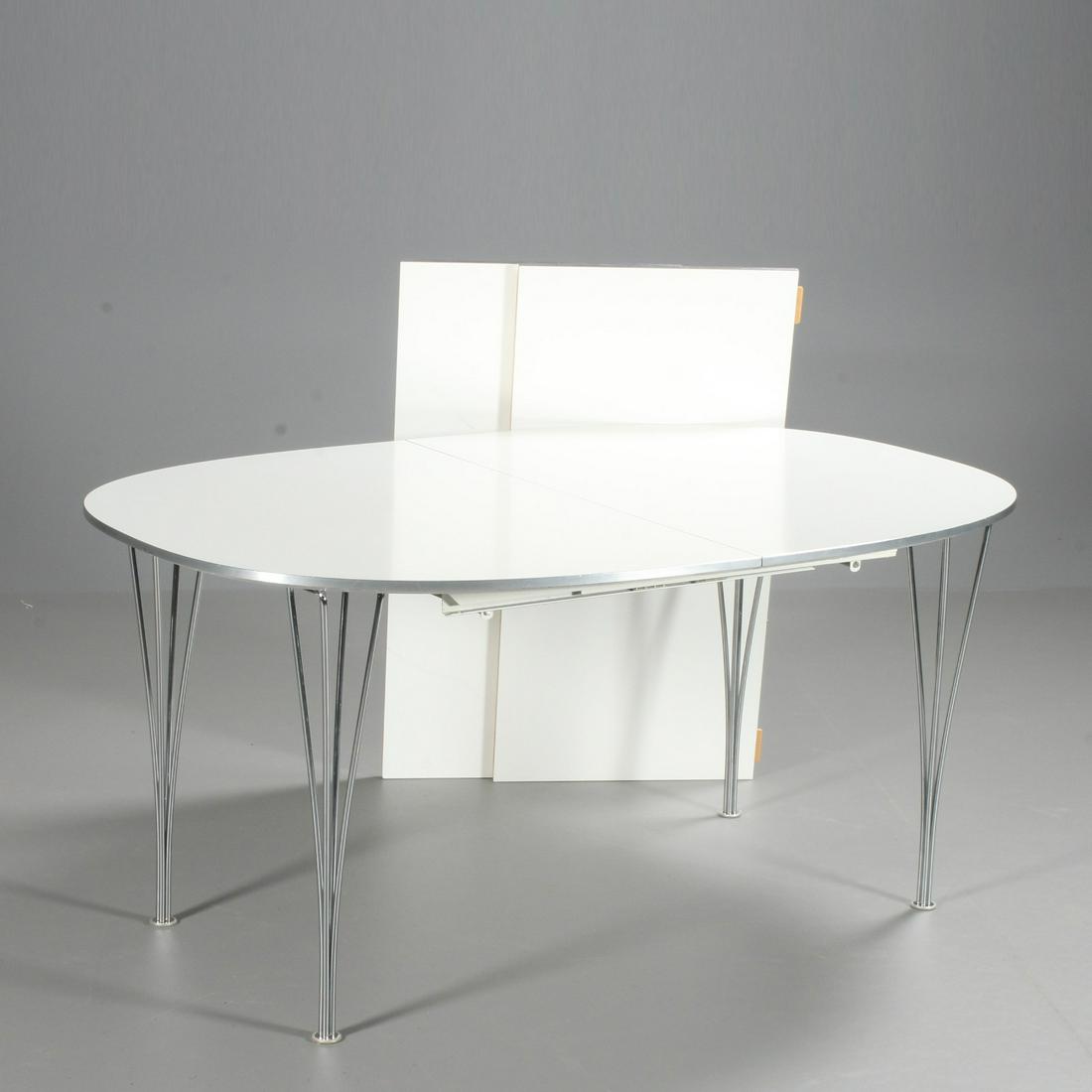 Piet Hein & Bruno Mathsson. Superellipse dining table.: Superellipse dining table with white laminate top with pull-out, brushed steel edging mounted on chromed steel legs. In addition, two additional plates 50 x 100 cm. H. 71 L. 150 B. 100 cm.