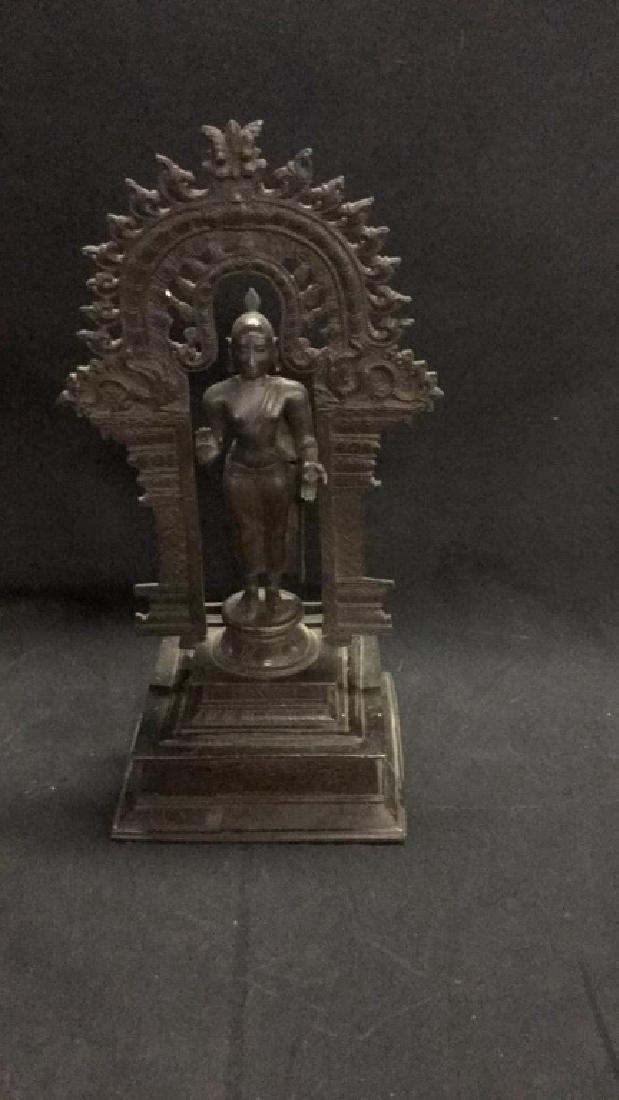 Metal Thai Buddha figure standing under archway (1 of 3)