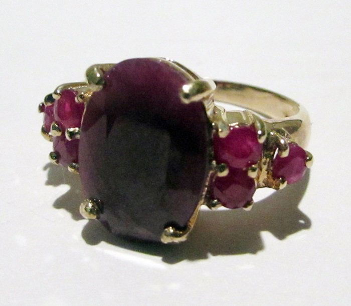 10K Yellow Gold Ruby Ring: This 10K yellow gold ruby ring is comprised of 4 prongs set oval cut ruby surrounded by channel set 6 round rubies. This estimated weight of the rubies are 3.85ctw. This estimated weight of the ring i