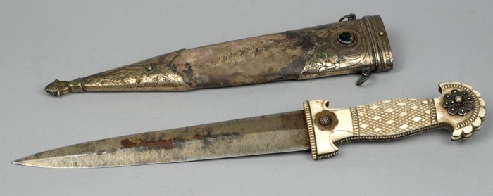 A 19th Century Middle Eastern ivory handled dress: the chequered handle beneath a fan-shaped pommel, with white metal stud, the scabbard with agate-set white metal mounts. 14 by in., 35 by 0cm.