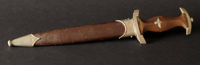 A WWII German S.A. Dagger: German Nazi SA Dagger with brown scabbard, blade maker marked `Solingen`, cross guard stamped `Wf`. 15 by in., 37.5 by 0cm.