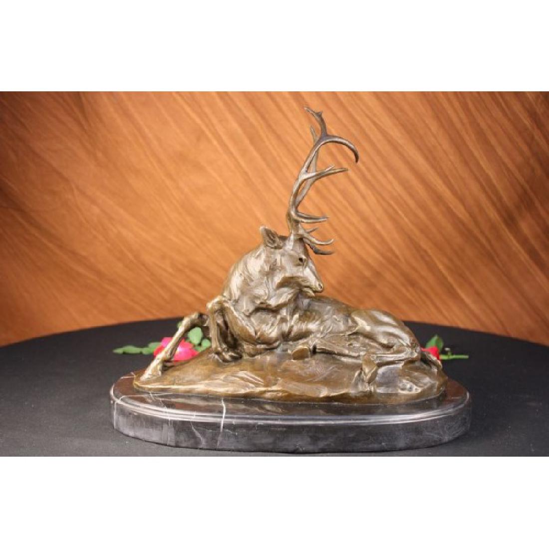 Elk-Buck-Stag trophy Bronze Statue on Marble Base: This old elk takes a rest from the summers day heat in a cool grassy area. He lies down and reaches his massive head around his back to scratch and itch that has been bothering him. He is old and his