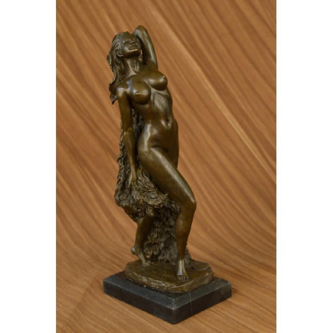Erotic Nude Lady Bronze Sculpture: _x000D_This is a depiction of a nude girl standing in a manner very reminiscent of a model pose. She is most likely standing on the beach, apparent by the rock structure she is standing on. She slight