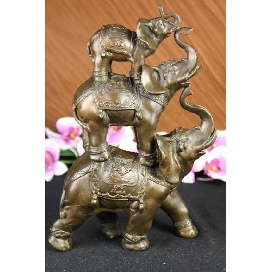 Sign Bologna Abstract 3 Elephants Family Bronze Statue: The bronze sculpture in its abstract composition shows three elephants ascending in size from largest to smallest with upturn trunks. They each wear a saddle that boast exquisite details with an Art D