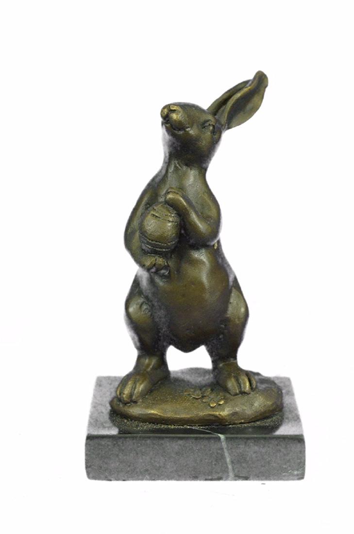 Easter Bunny Bronze Sculpture: This cute and cuddly lil lady looks up with the sweetest look and holds a tiny basket full of flowers in her tiny arms. This little bunny is the perfect touch of decor for a sweet and cute look. Her e